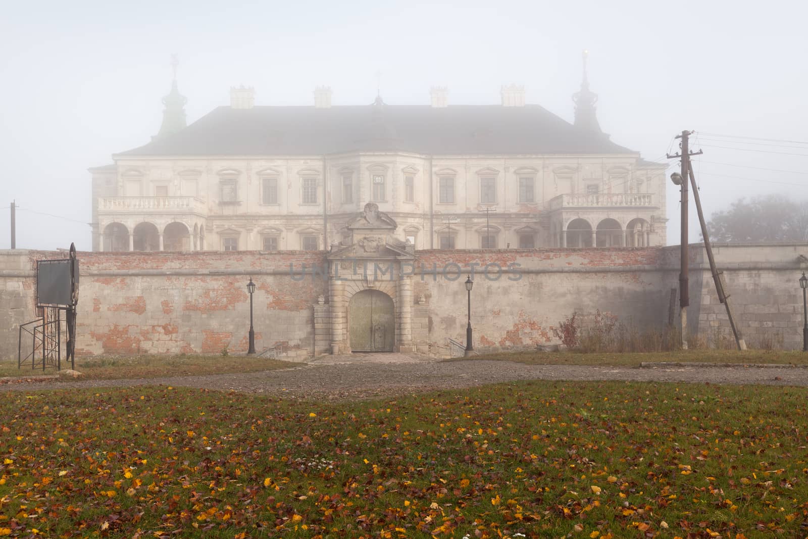 Ancient castle in the morning fog. Autumn season