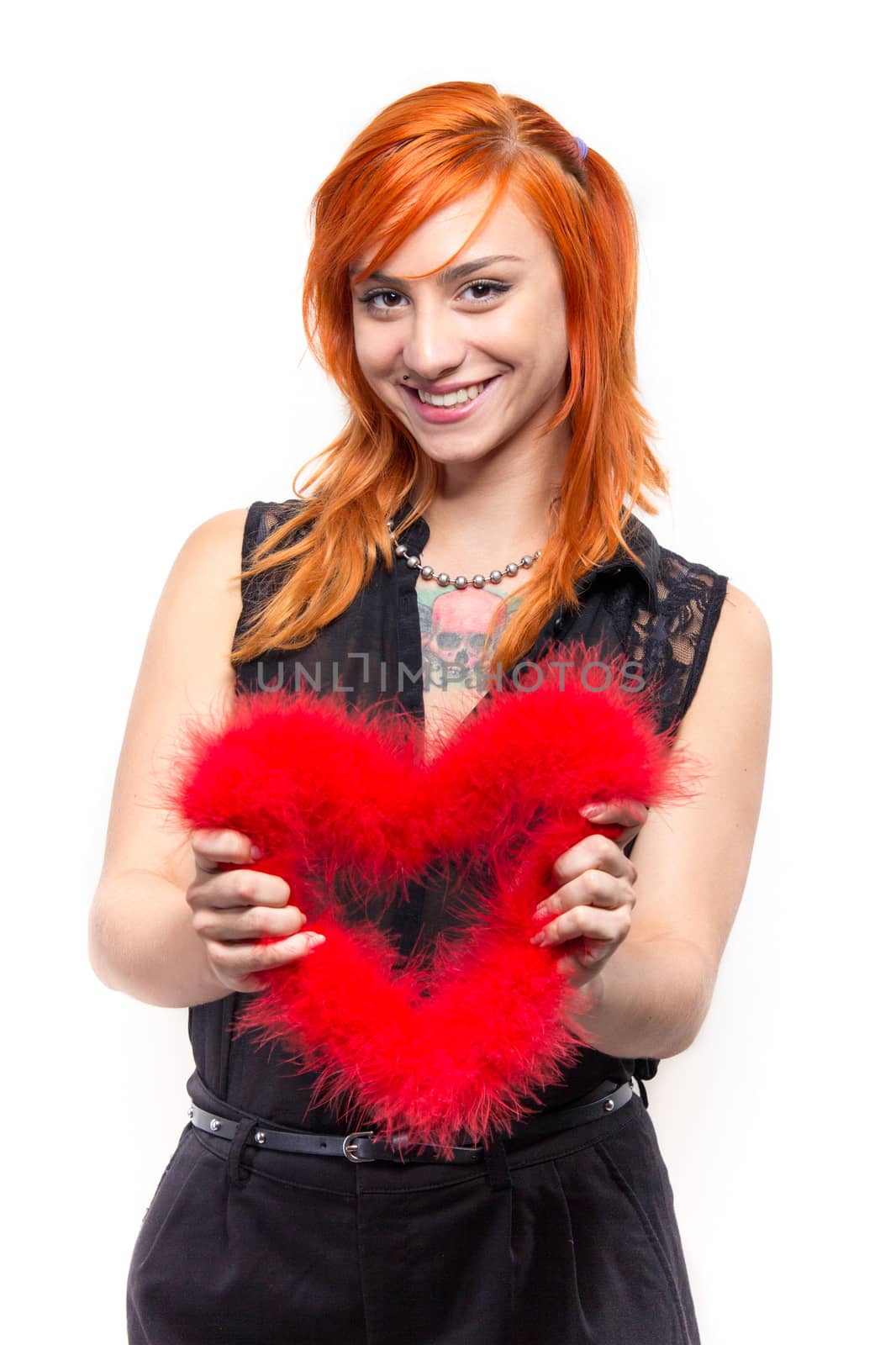 Smiling pretty girl holding a heart made of bird feathers