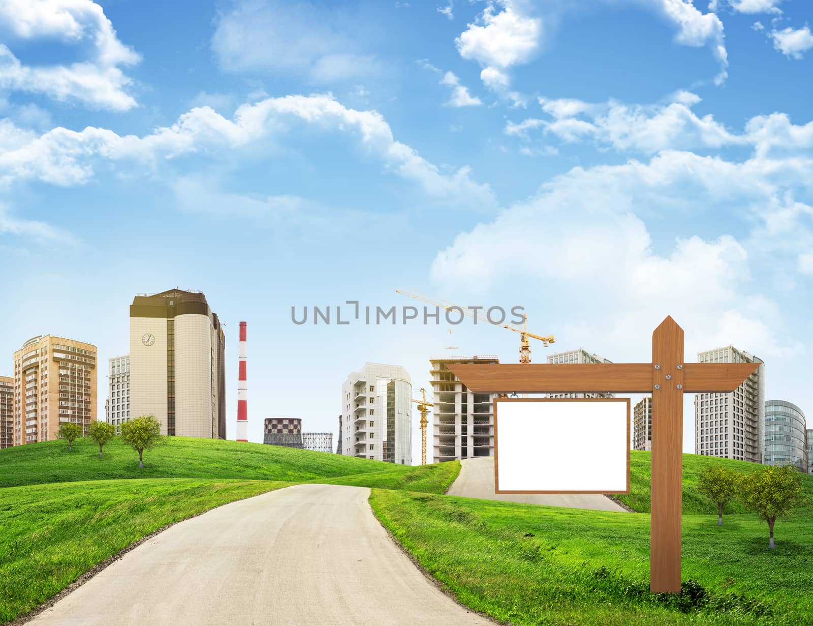 Buildings, green hills and road with wooden signboard against sky by cherezoff