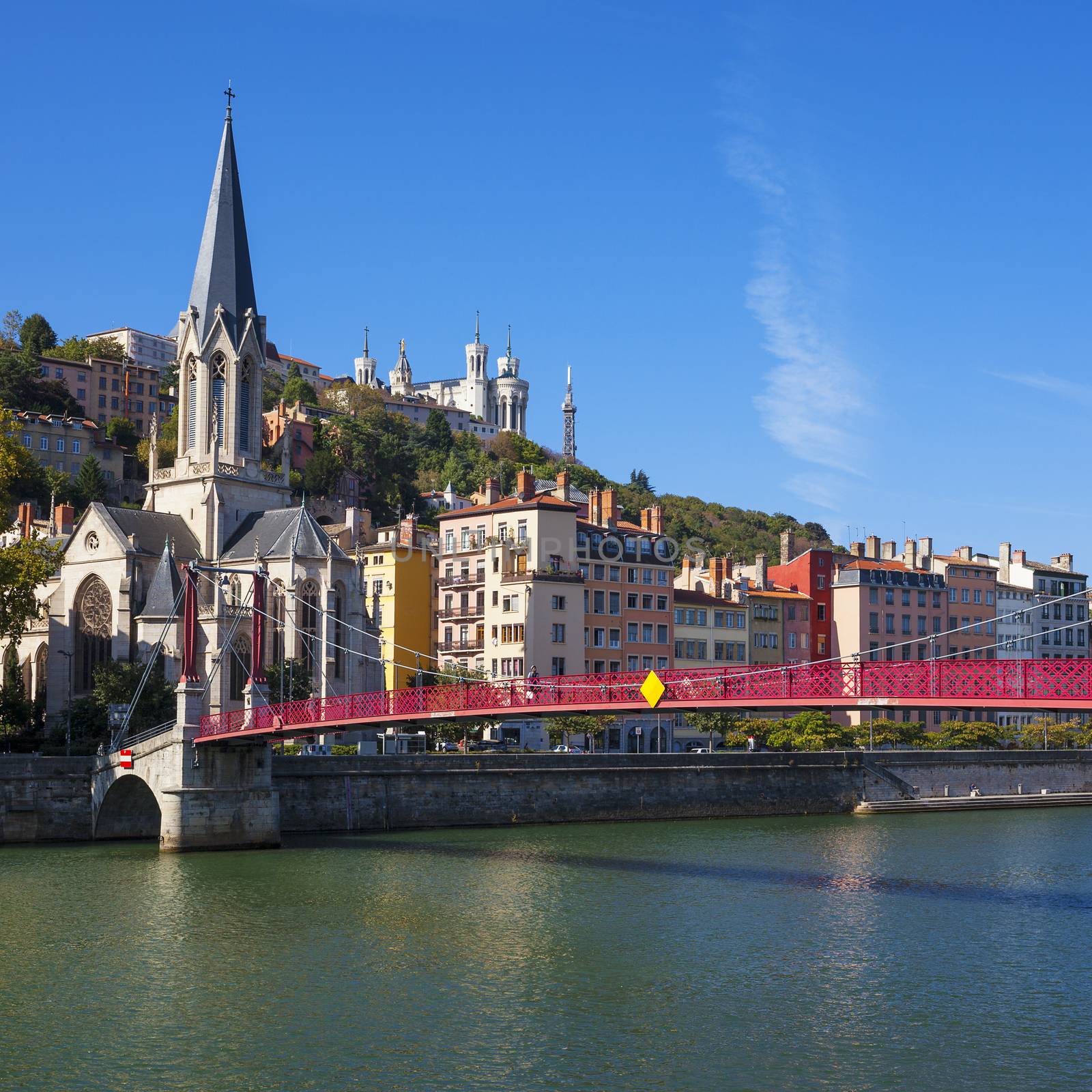 Famous view of Lyon city with red footbridge on Saone river and church 