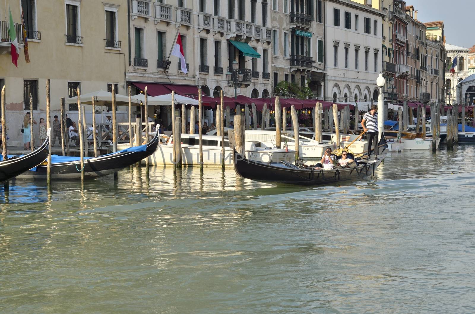 Gondola sailing with tourists at the Grand Canal in Venice, Italy. 