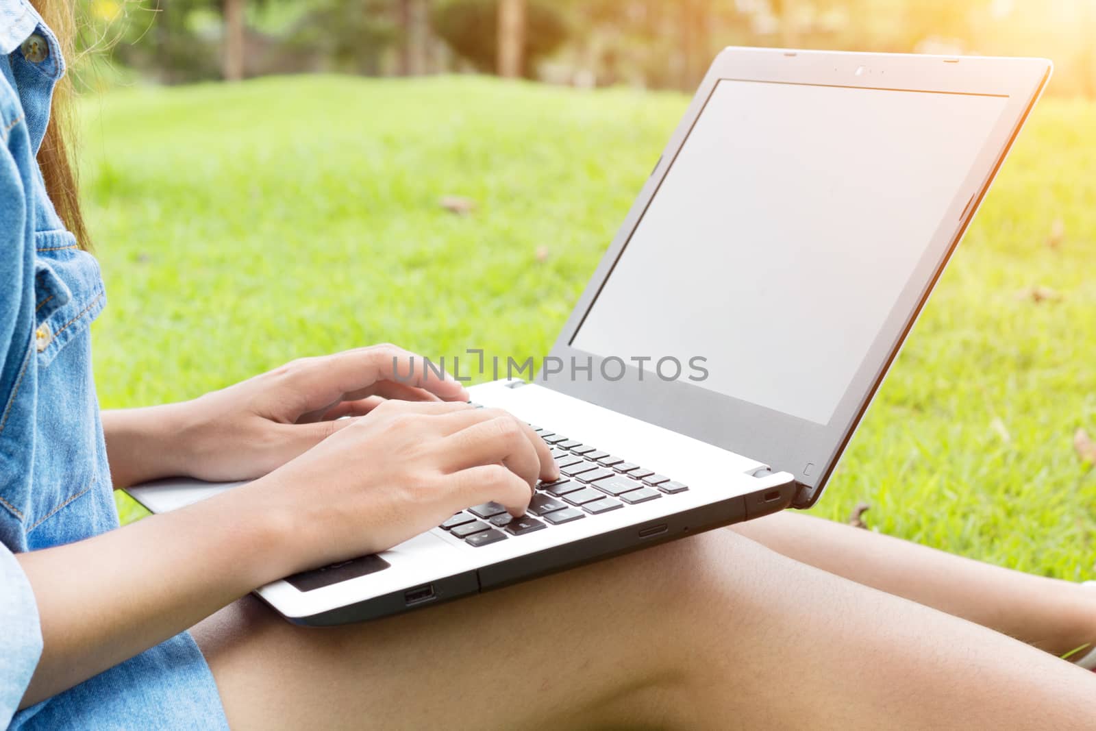 woman use laptop computer in the park by blackzheep