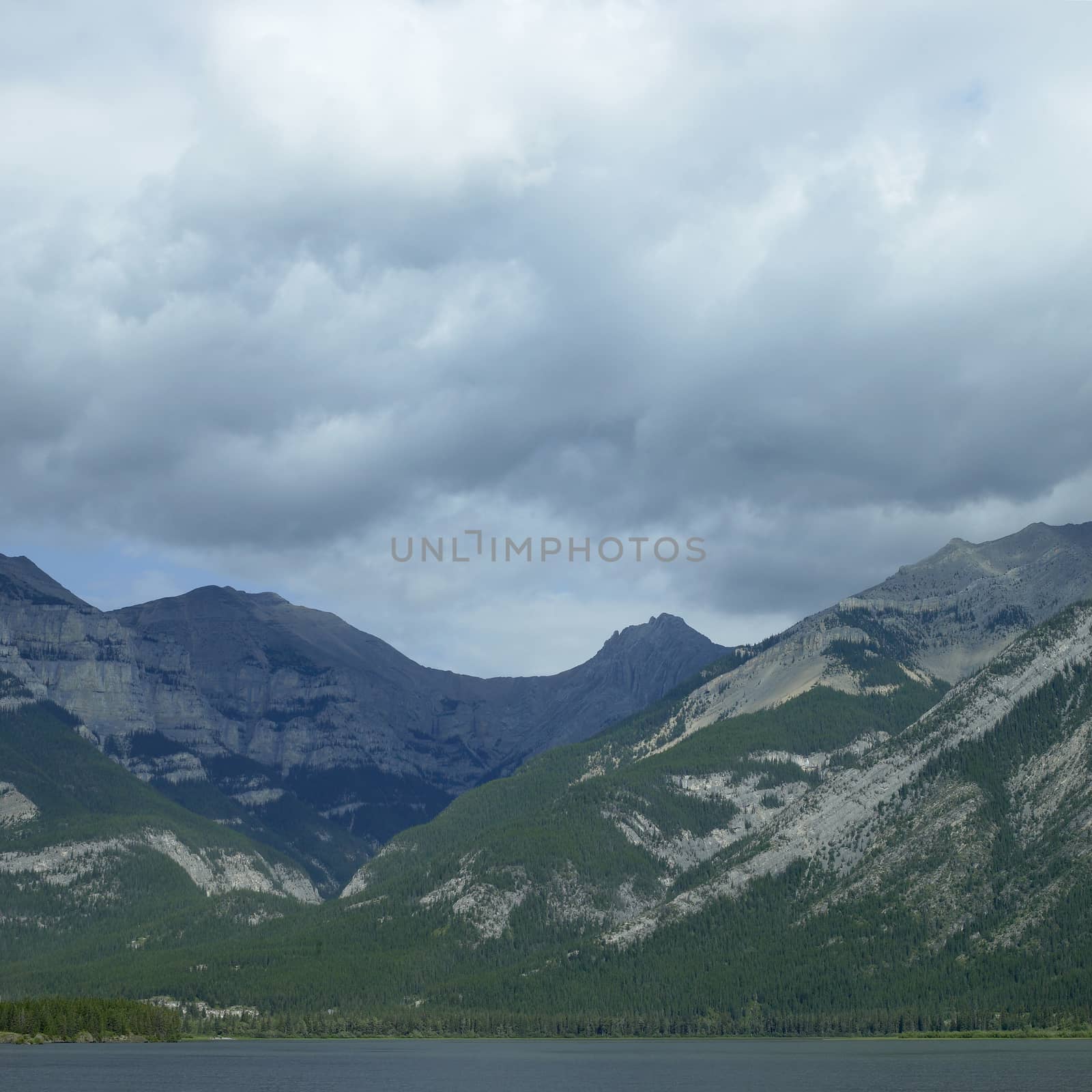 Large rocky mountains with trees and lake
