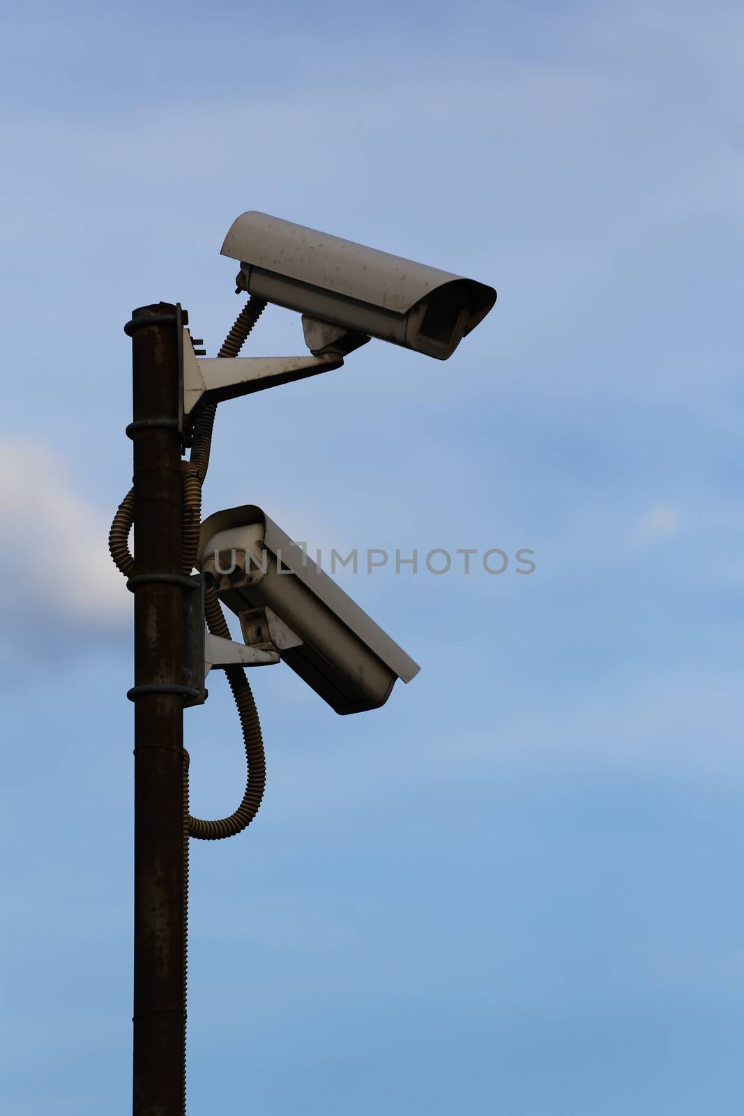 Two surveillance cameras against the sky