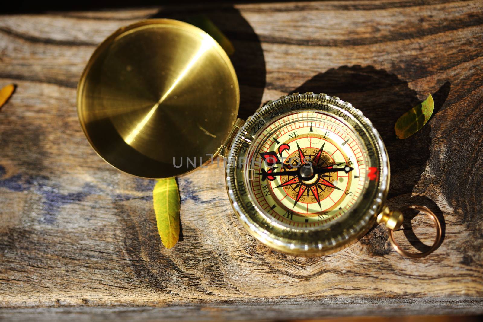 An old fashion compass on wooden plank close up shallow dof