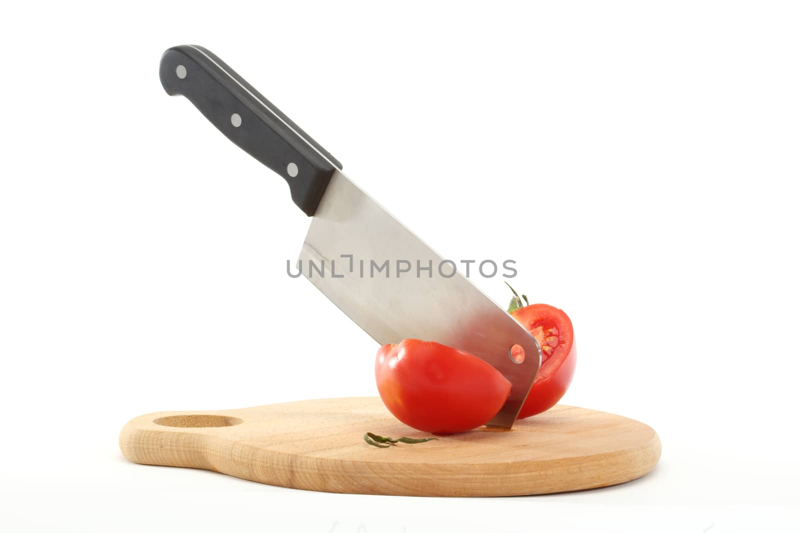 cleaver bisects tomato on cutting board