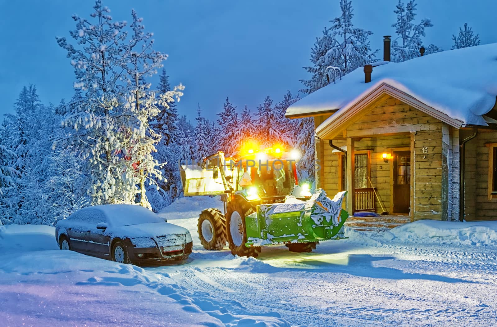 Tractor cleaning snow near house in winter finland  by erix200511@mail.ru