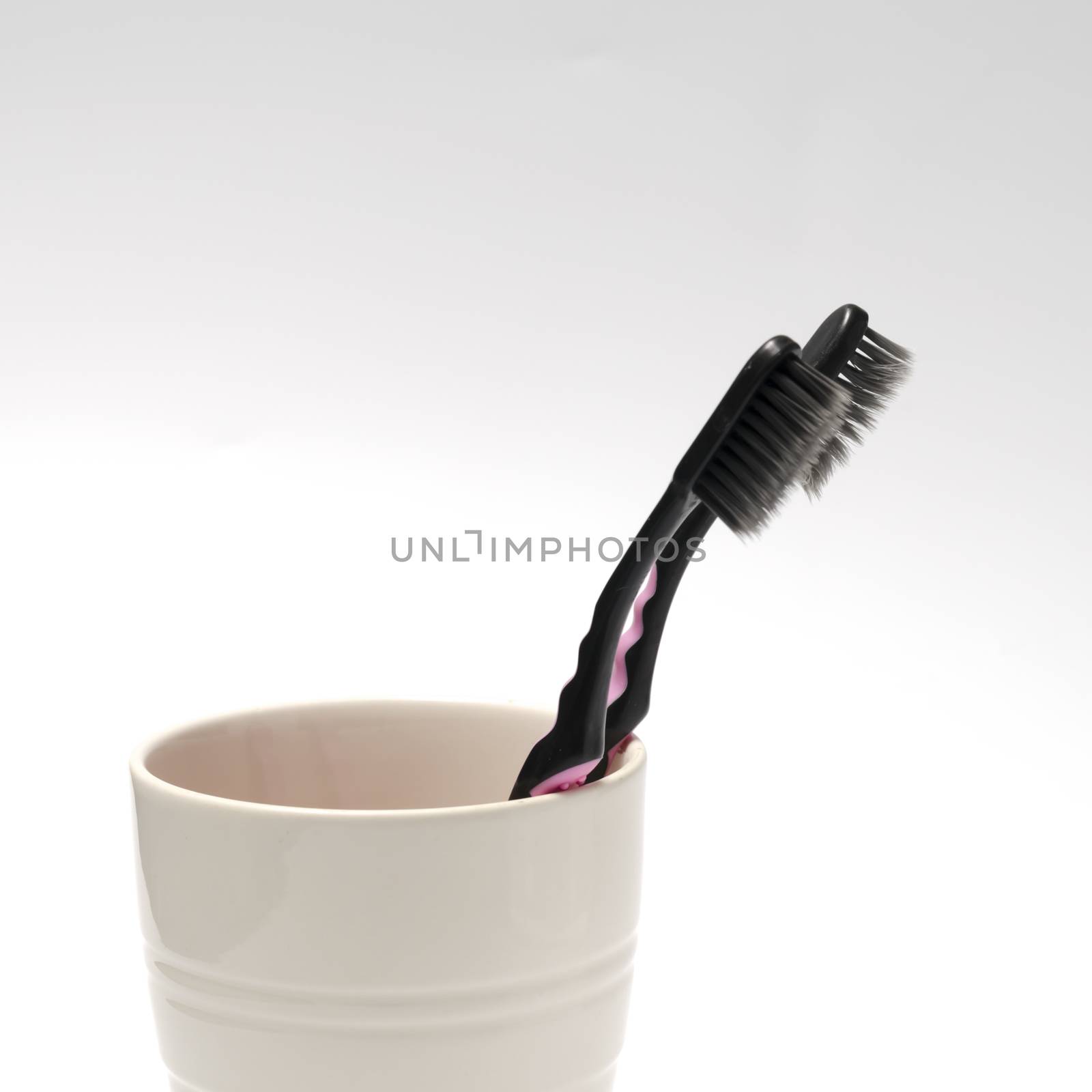 tooth brush in glass on a white background