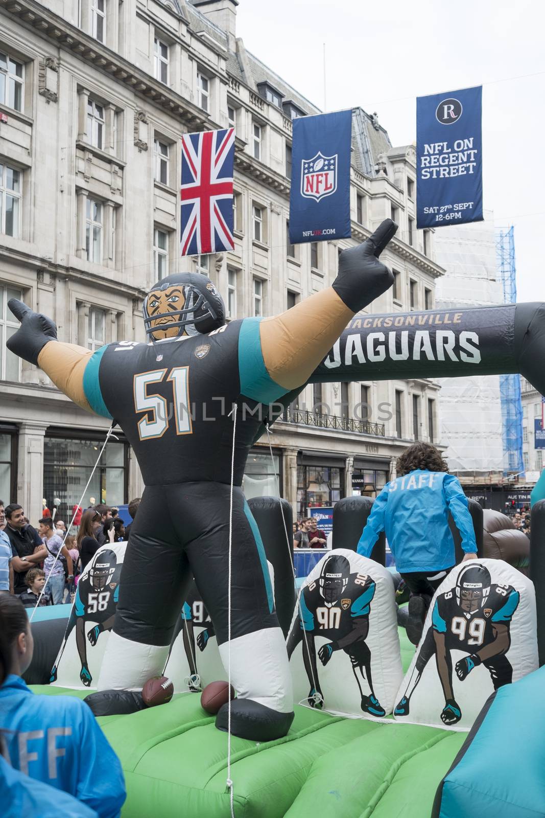 LONDON UK - SEPTEMBER 27: Jacksonville Jaguars inflatable player and NFL flags in Regent Street. September 27 2014 in London. The street was closed to traffic to host NFL related games and events.