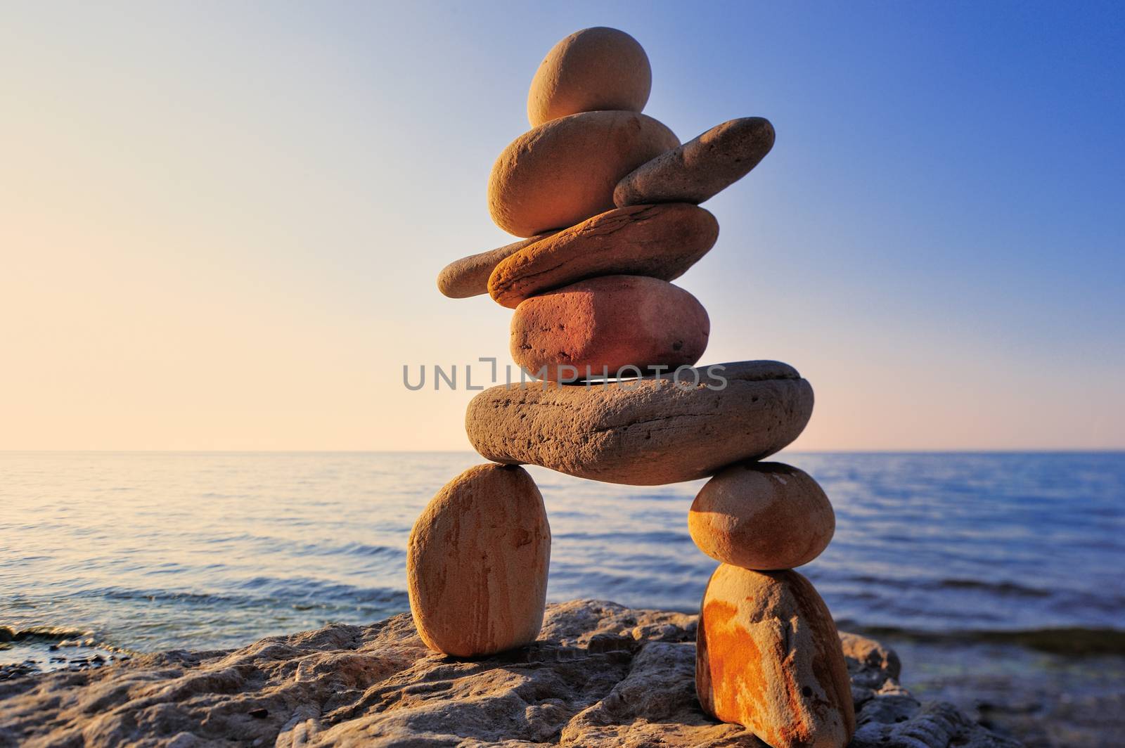 Figure of inukshuk on the seacoast against the sunset