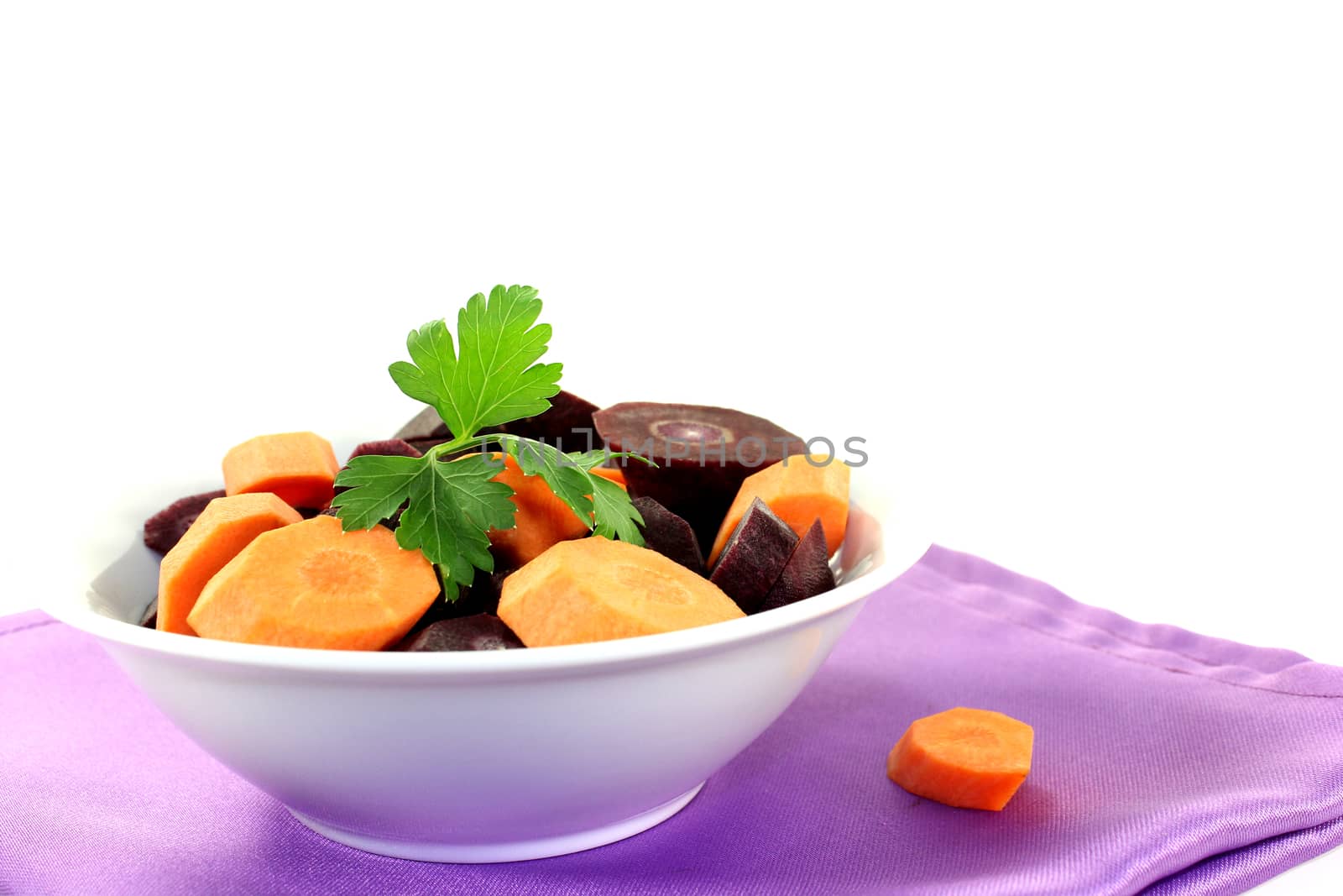 sliced orange and purple carrots on a light background