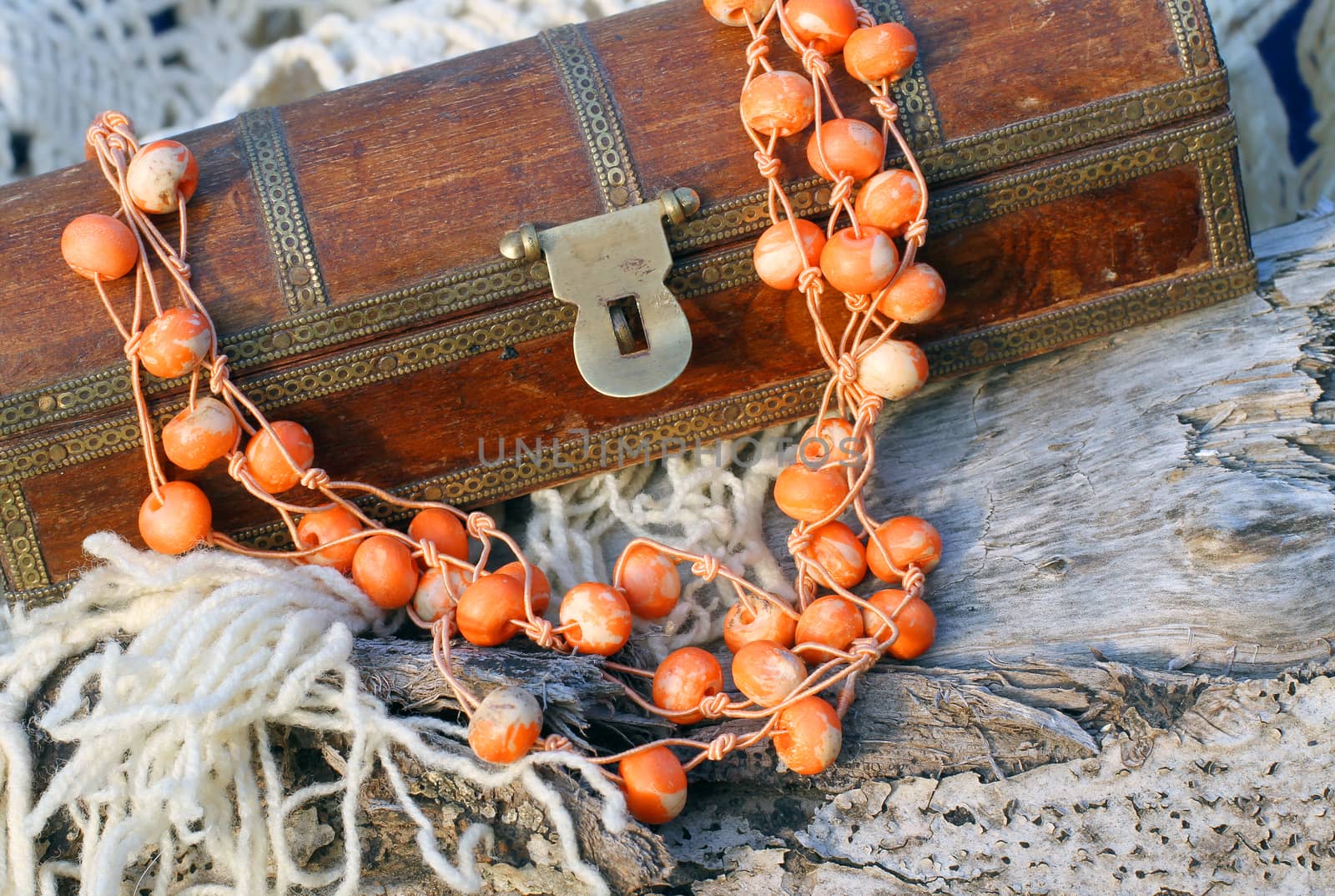 Ethnic handmade wooden necklace and old wooden chest on autumn-style background 
