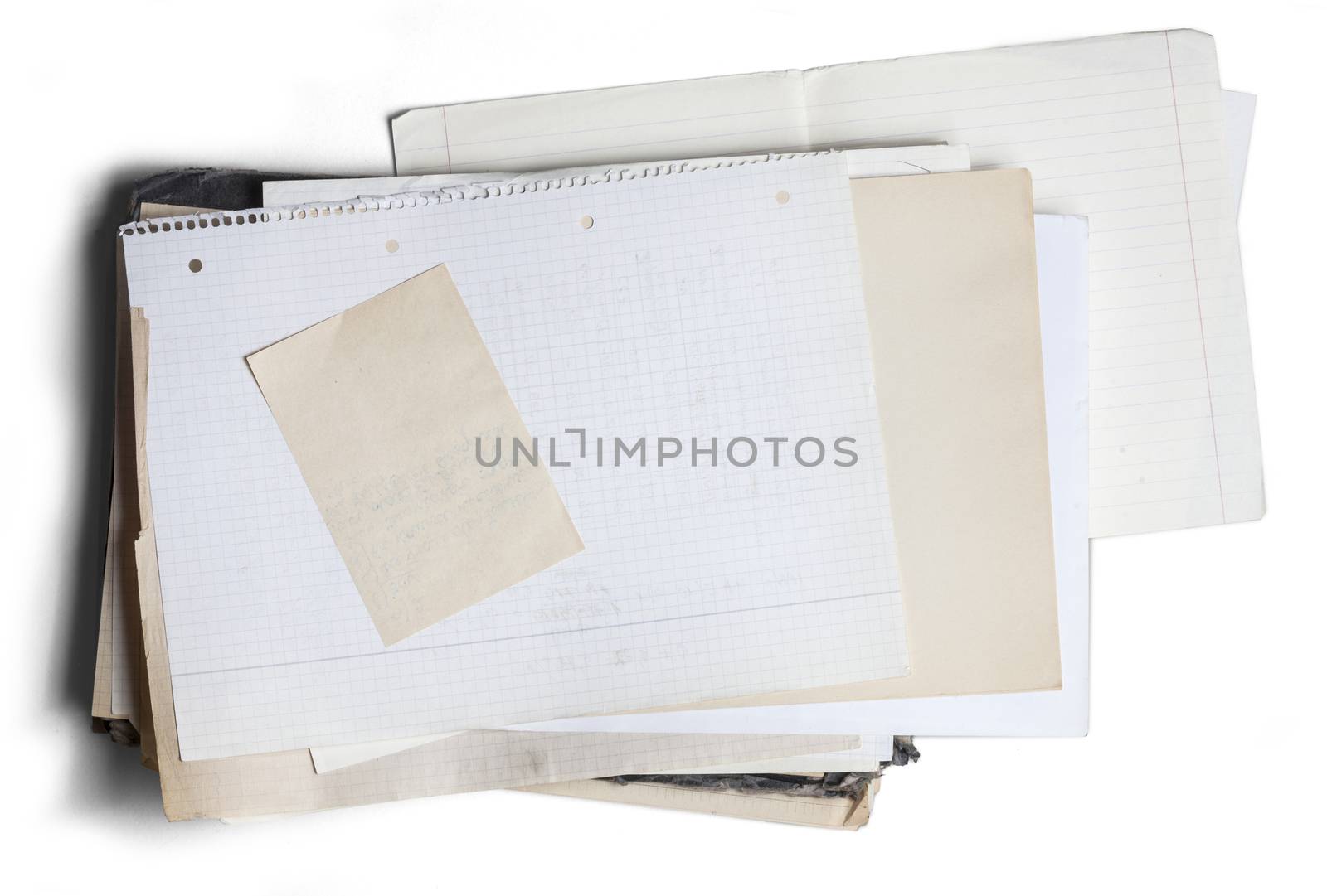 Sheet of yellowed and square graph paper on pile of aged papers