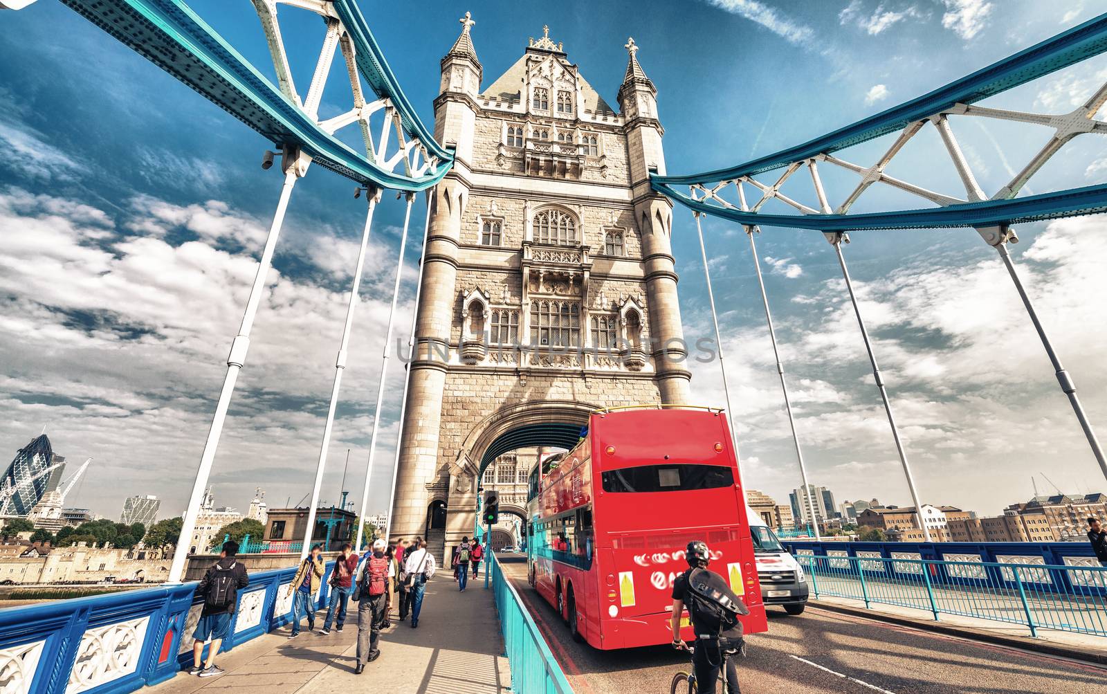 Red bus crossing Tower Bridge on a beautiful summer day - London by jovannig