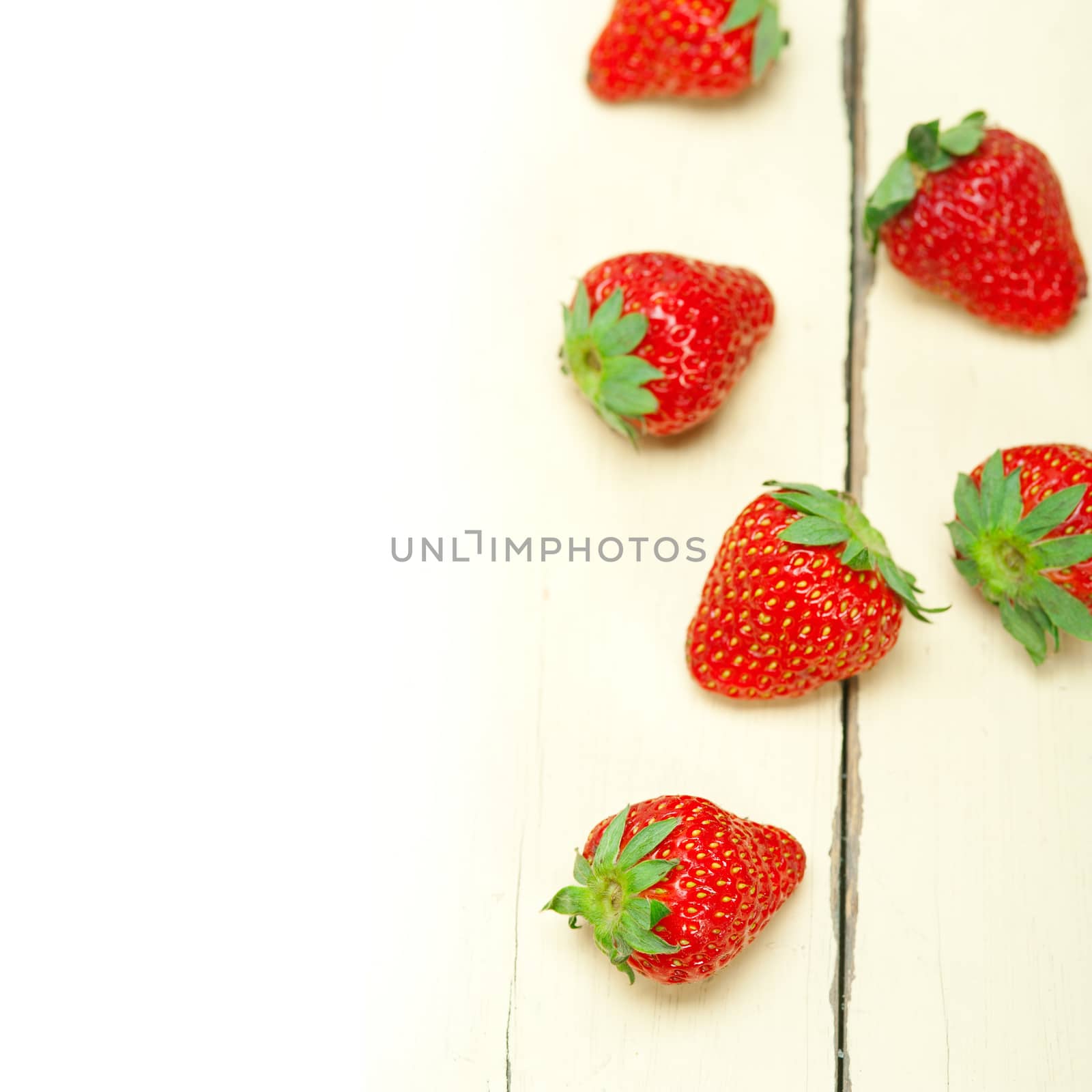 fresh organic strawberry over white wood by keko64