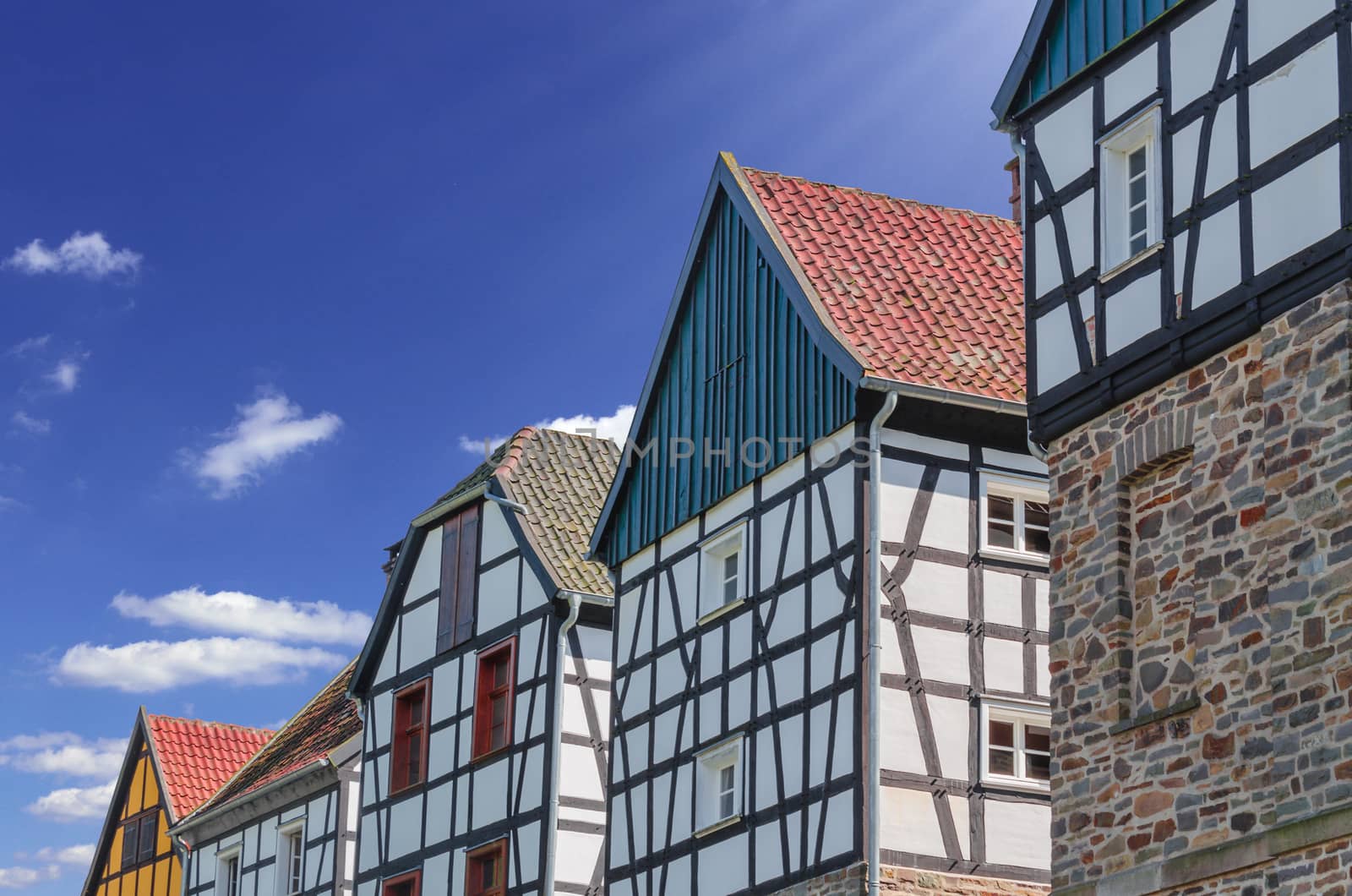 Idyllic, gable view of various half-timbered houses against a blue sky.