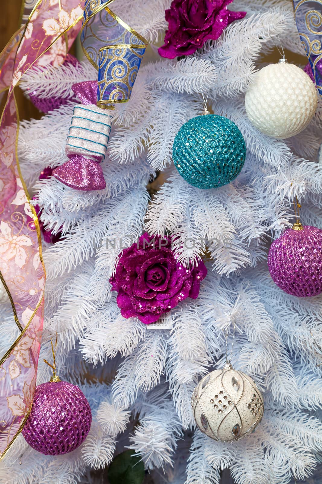 the white New Year tree decorated with tapes and toys