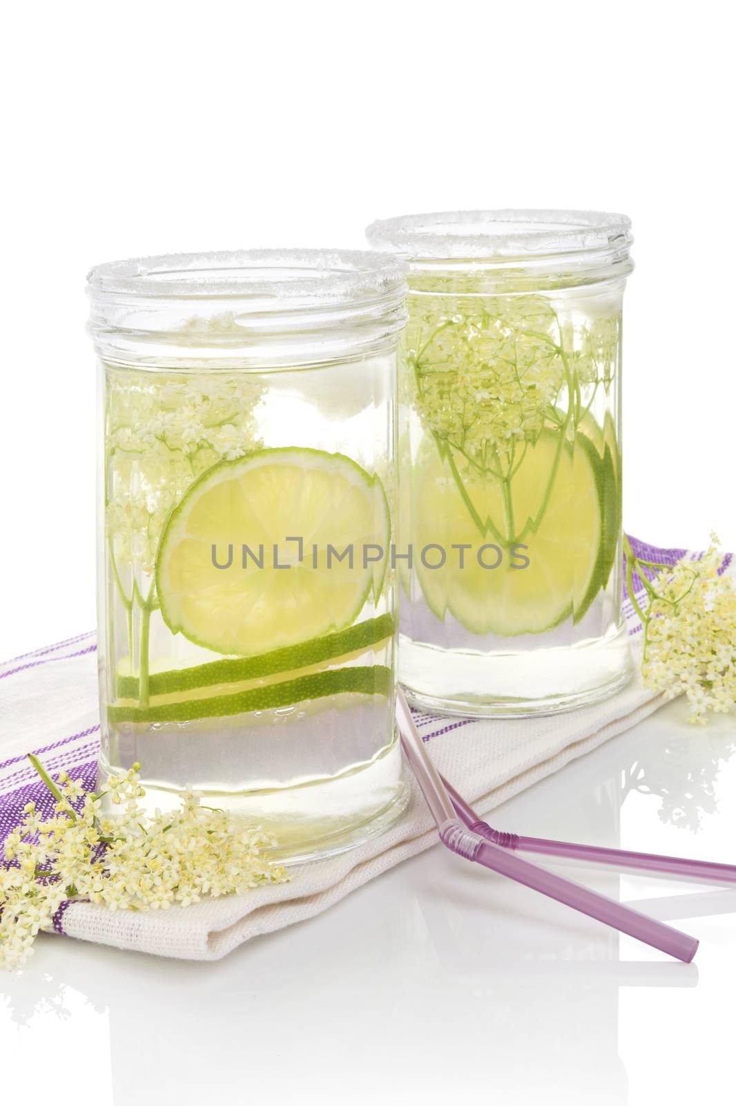Elderberry lemonade. Two glasses with elderberry lemonade with ice and lime slices isolated on white background.