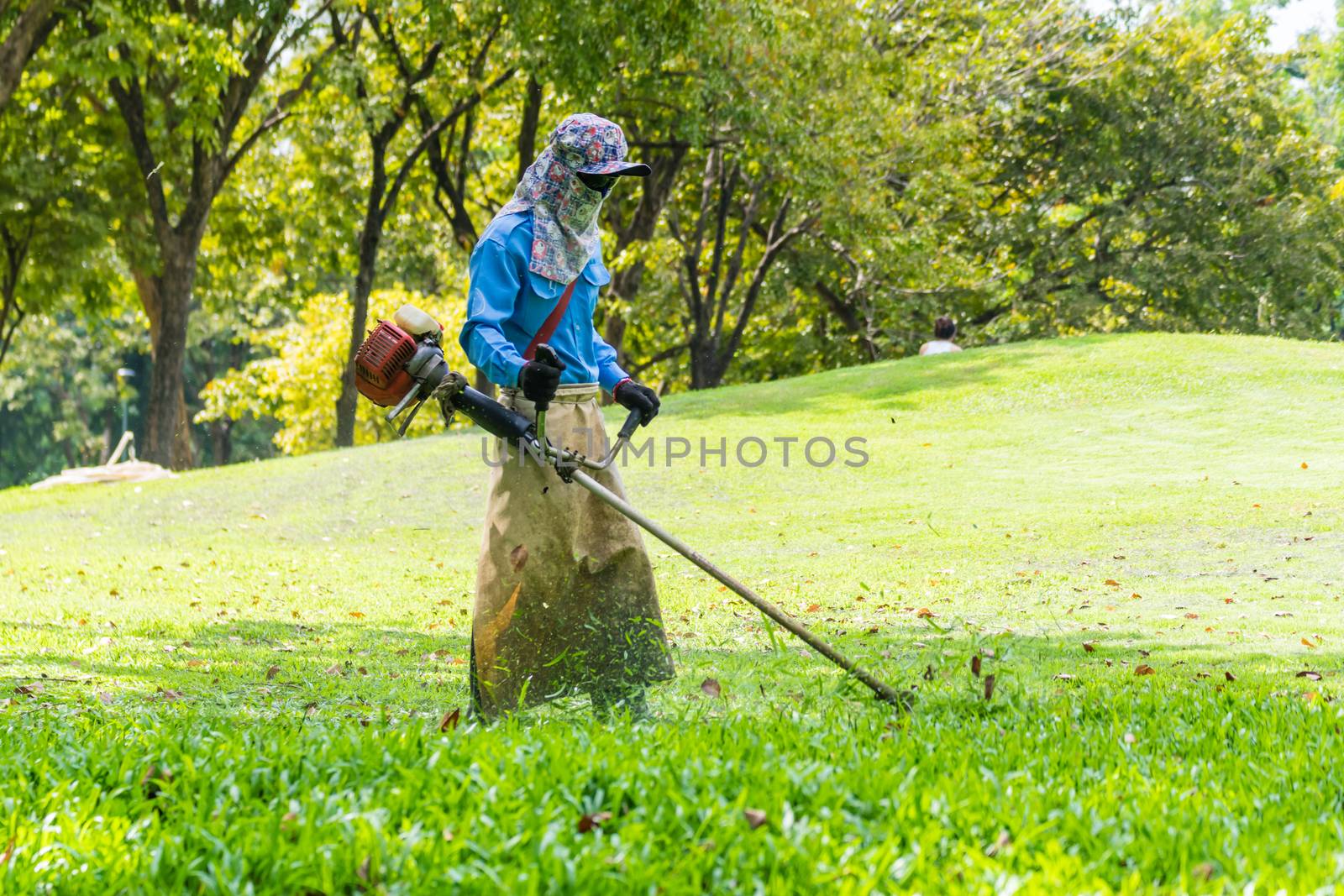 lawn mower worker man cutting grass in green field park