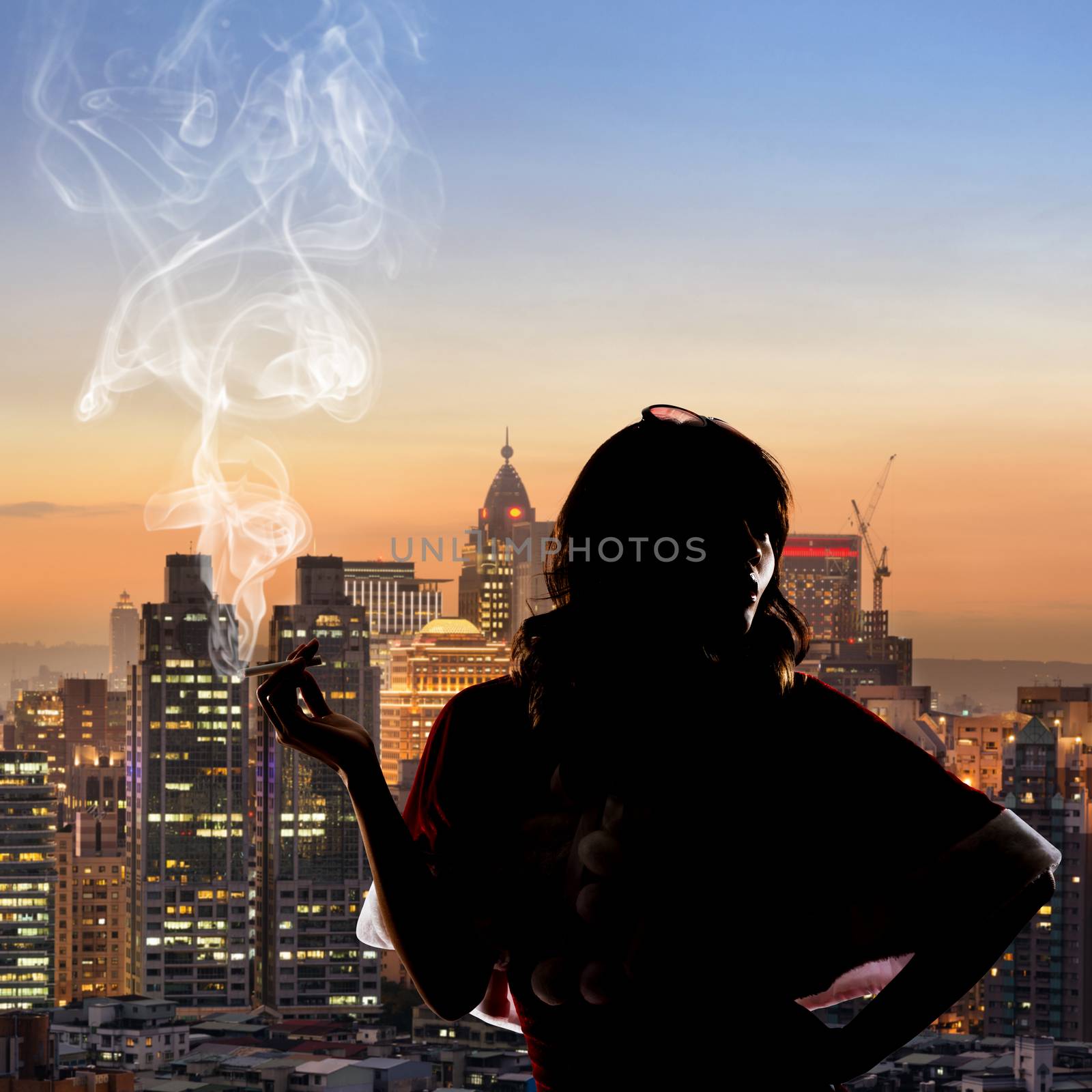 Silhouette of Asian christmas girl holding a cigar in the city night.