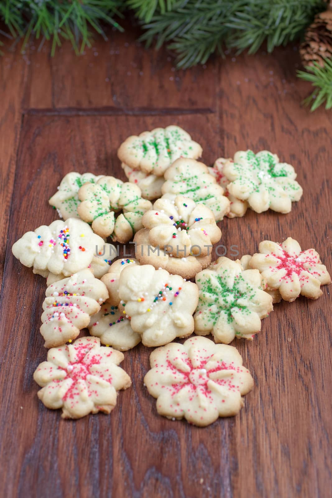 Christmas cookies sitting on a table with some greenery in the background.