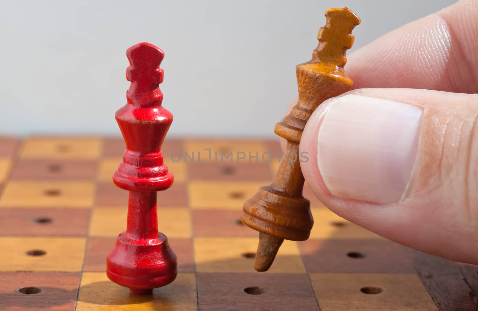 Hand with playing wooden chess kings. 