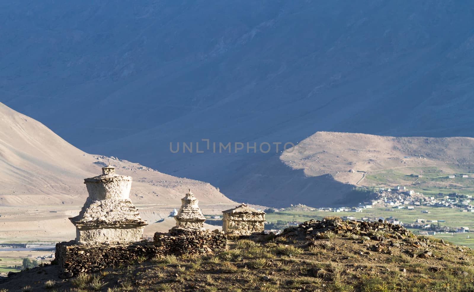 Buddhist stupas in the Zanskar  valley on the background of the mountains and village by straannick