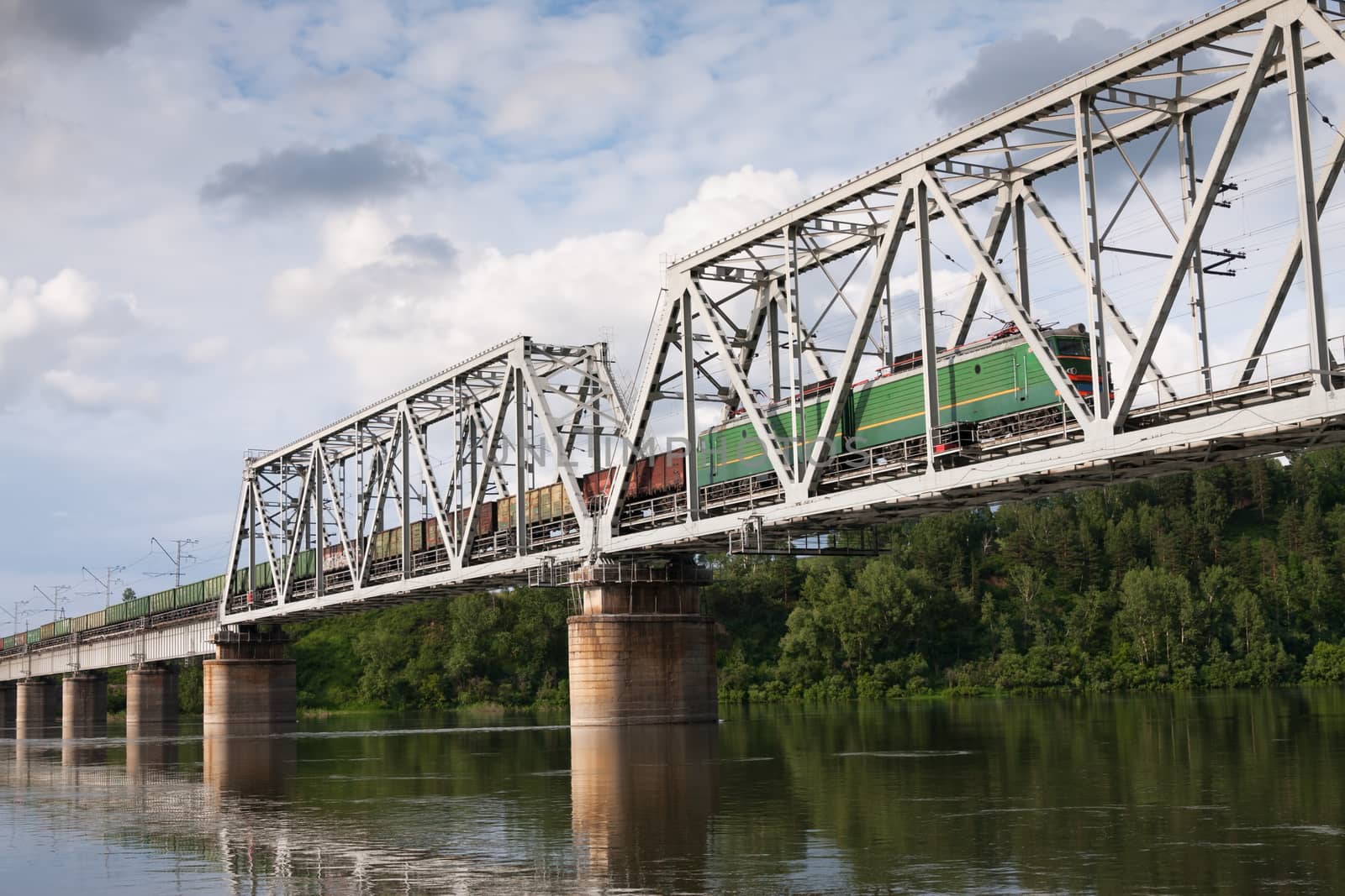 locomotive pulling a freight train on the railway bridge over the river