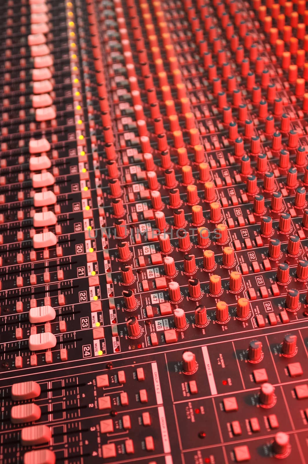 studio soundboard under red lighting