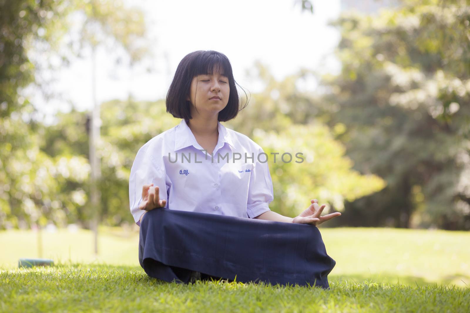 Student is sitting on the lawn. Concentration and meditation