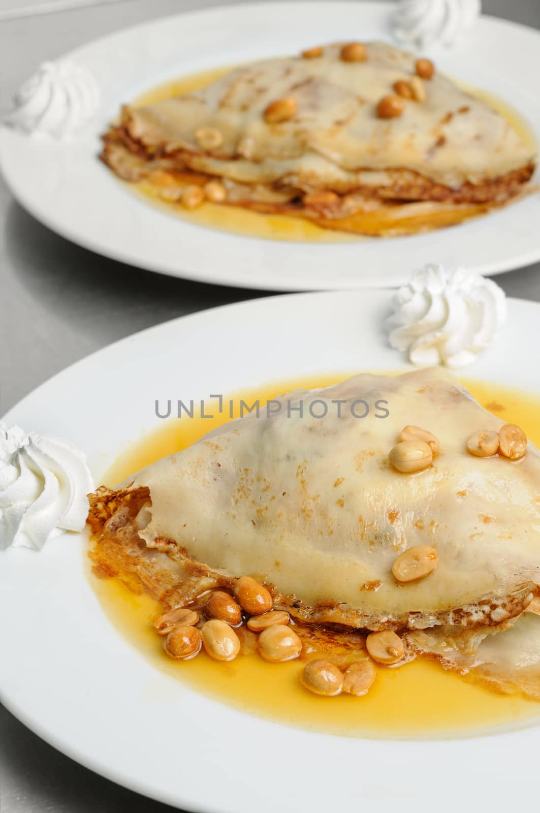 pancake crepe with peanuts and honey decorated with whipped cream