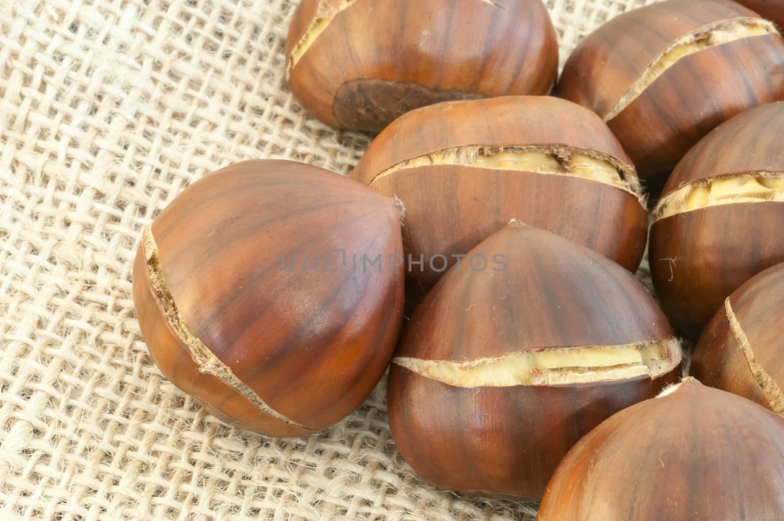 raw natural macro of chestnuts in jute background