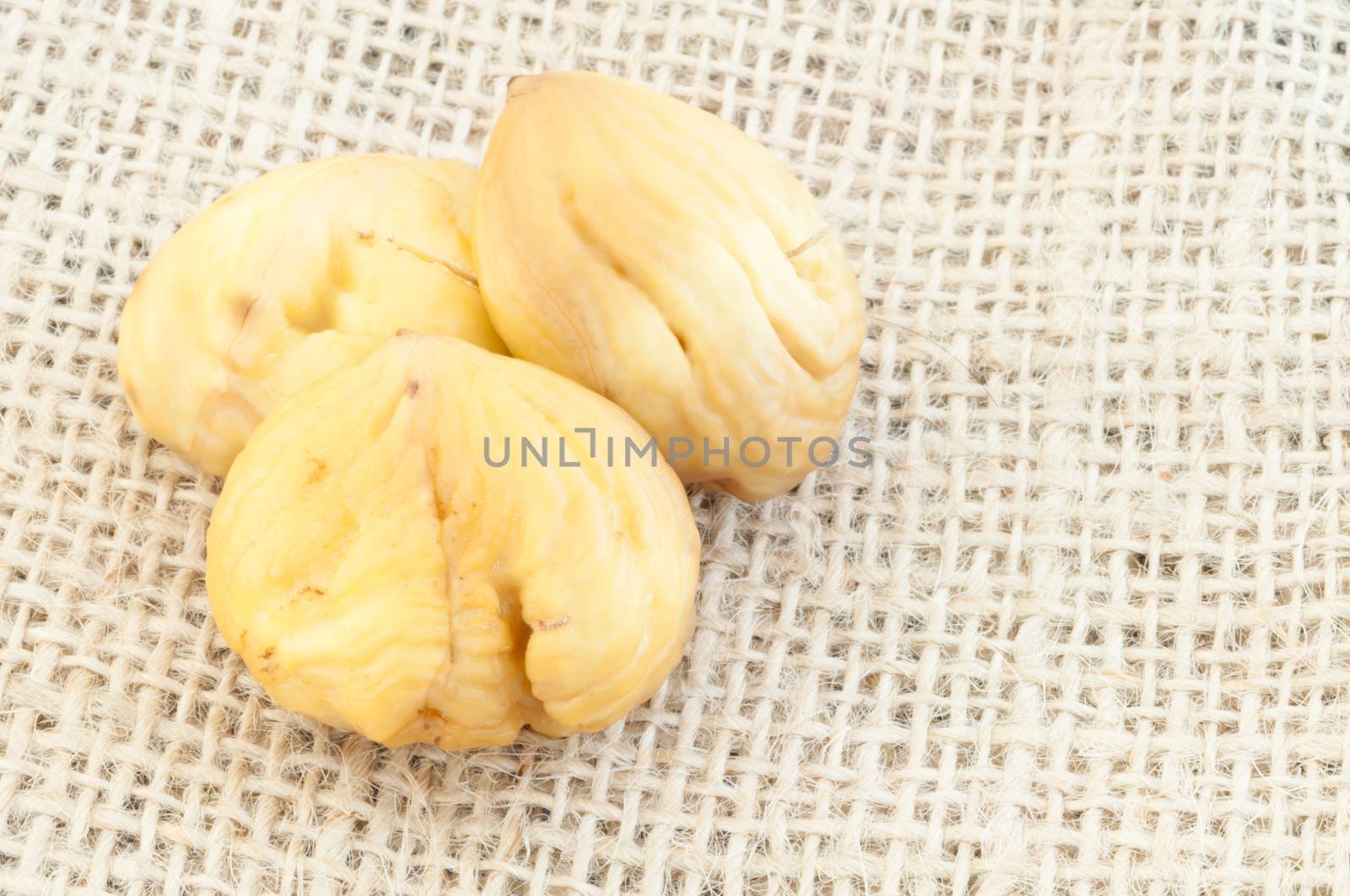 raw natural macro of chestnuts in jute background