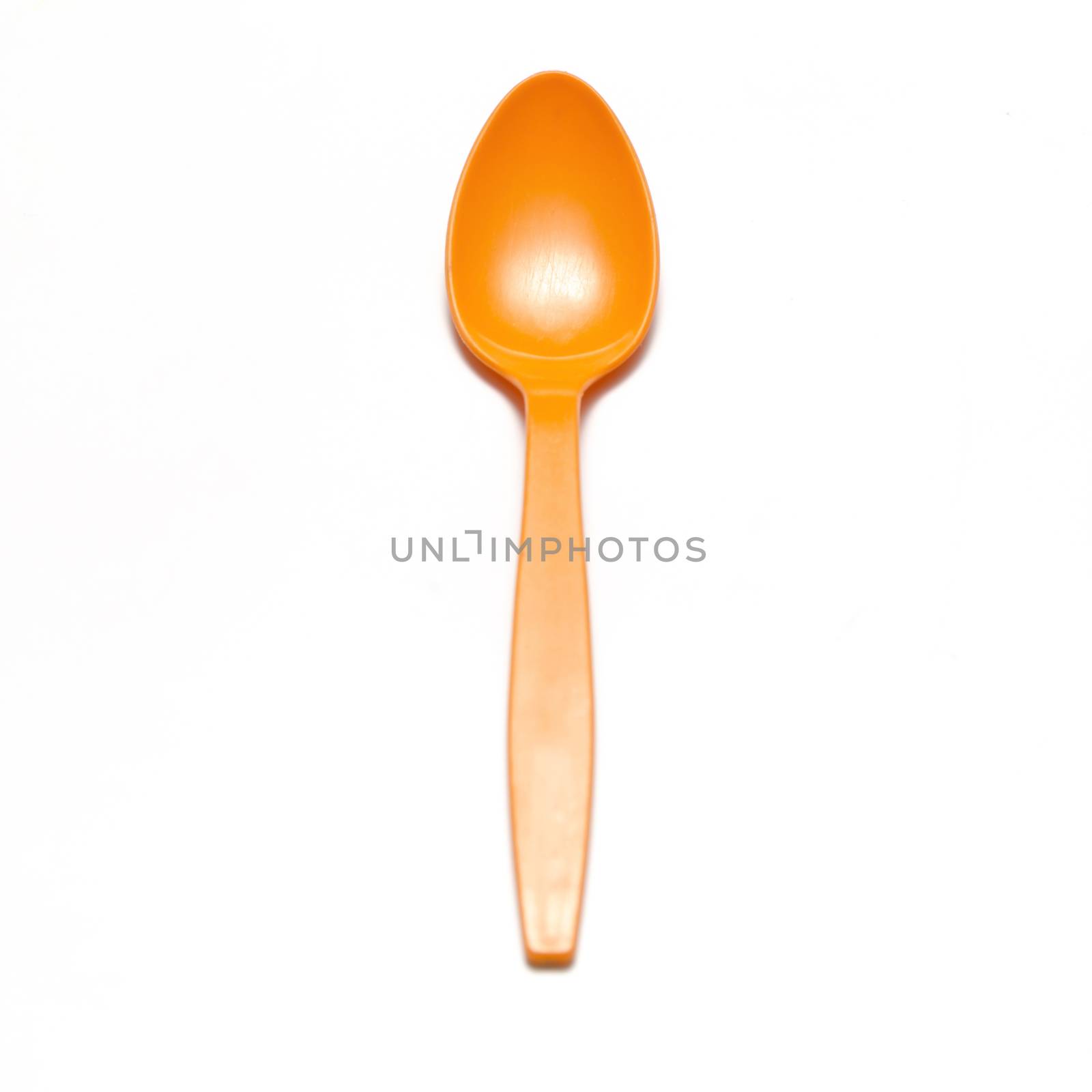 orange plastic spoon on a white background