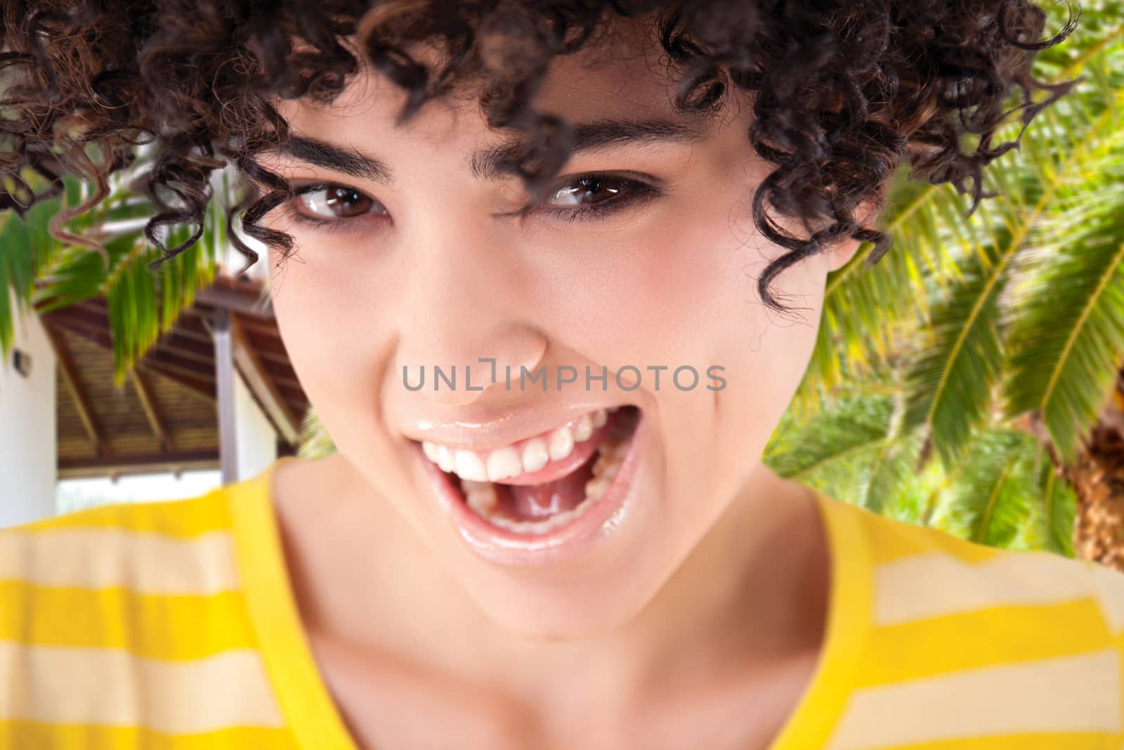 Young girl with curly hair and shirt with yellow stripes, tropical background, isolated with work path.