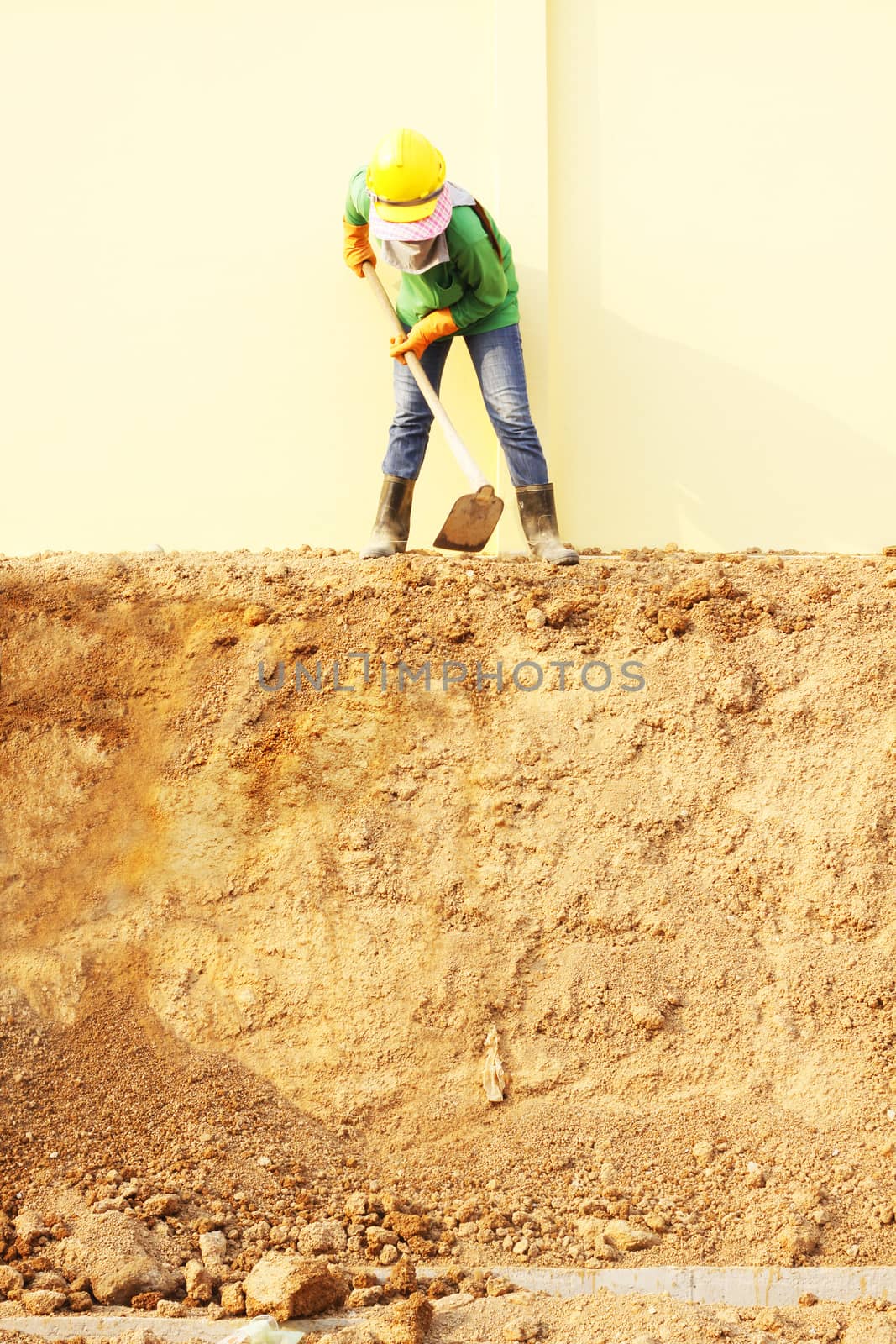 Laborer digging with hoe on construction site