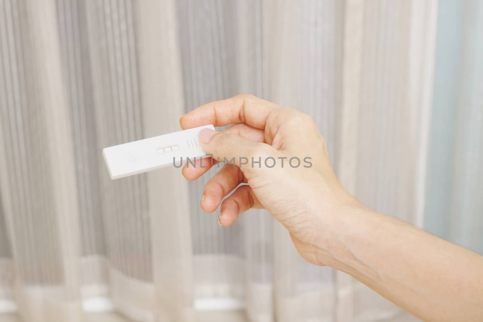 woman hand holding a positive pregnancy test 