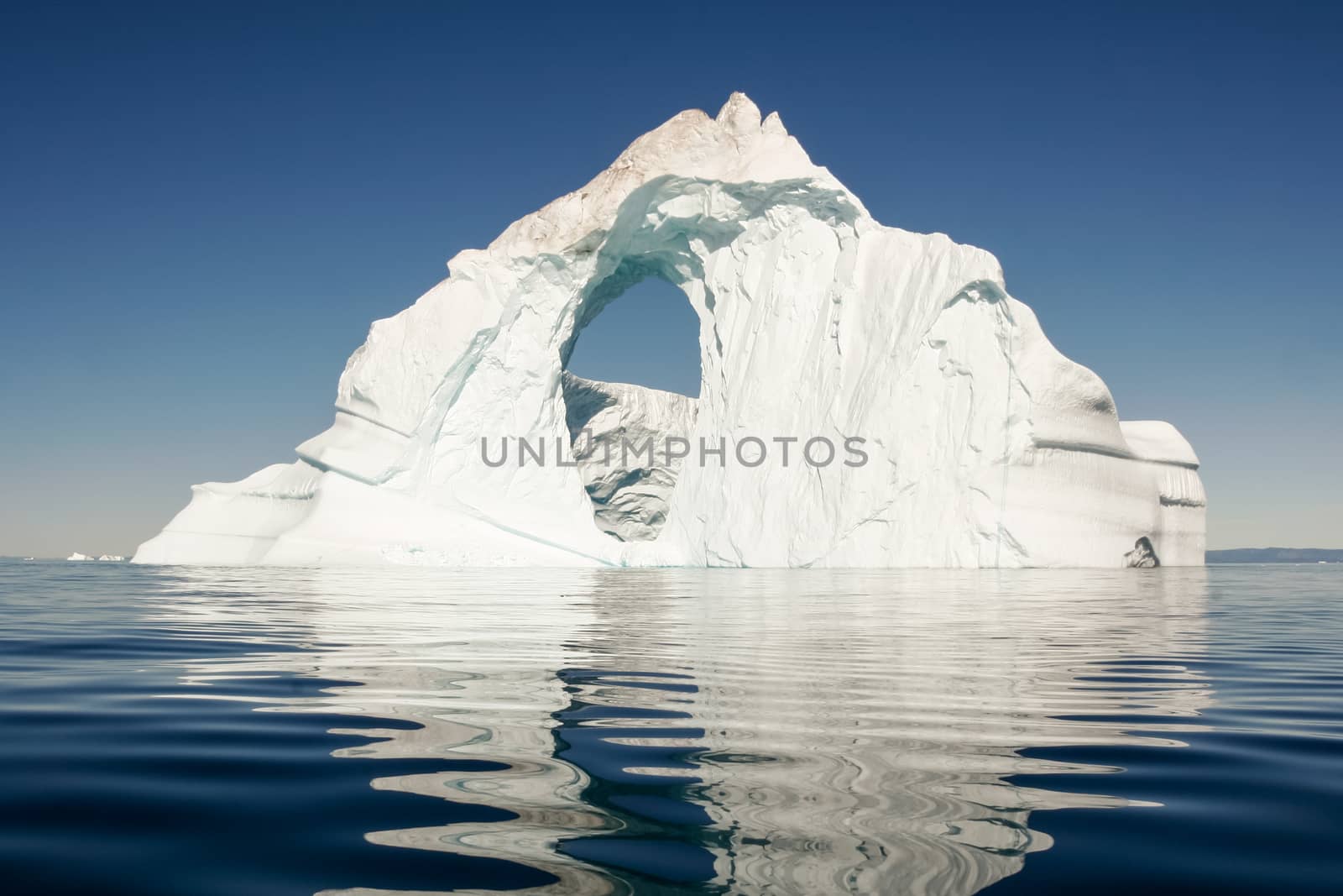 A lone ice berg sits in the still, deep blue sea. by Sprague