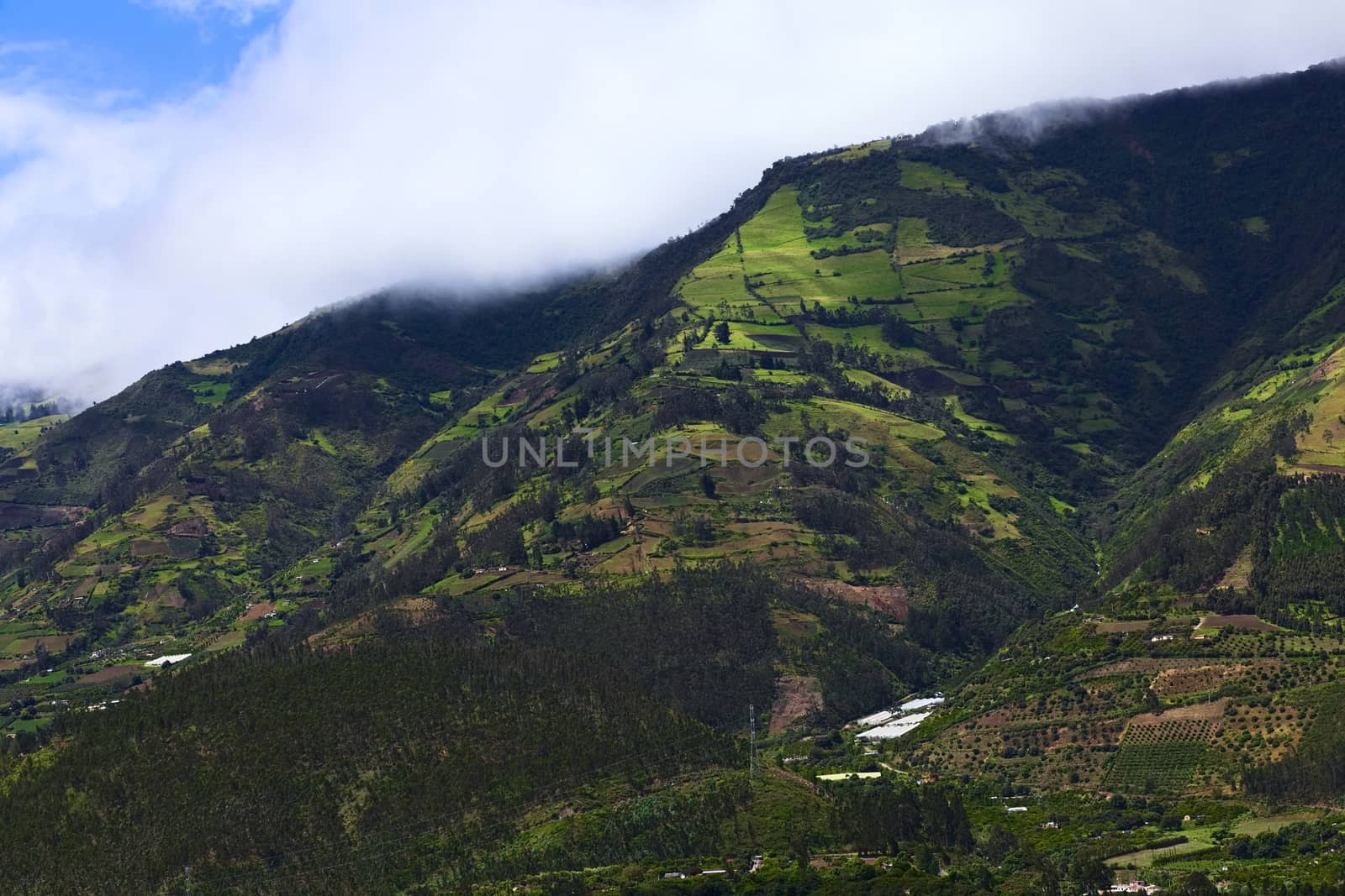 Rural hillside landscape with forests, small farms and orchards along the road between Ambato and Banos in Tungurahua Province in Central Ecuador. Even though the area lies relatively high (around 1800-2000 meters), many fruits and vegetables are being grown here.
