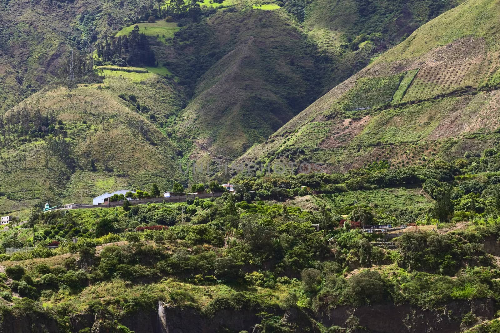 Rural hillside landscape with houses, orchards and trees along the road between Ambato and Banos in Tungurahua Province in Central Ecuador
