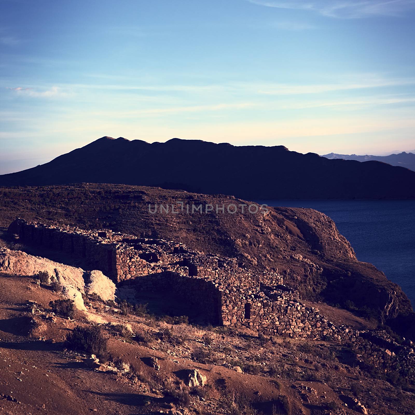 Chinkana archeological site of Tiwanaku (Tiahuanaco) origin on the Northwestern part of the Isla del Sol (Island of the Sun) on Lake Titicaca in Bolivia lit by the setting sun. Isla del Sol is a popular tourist destination and is reachable by boat from Copacabana, Bolivia. (Cross processed image)