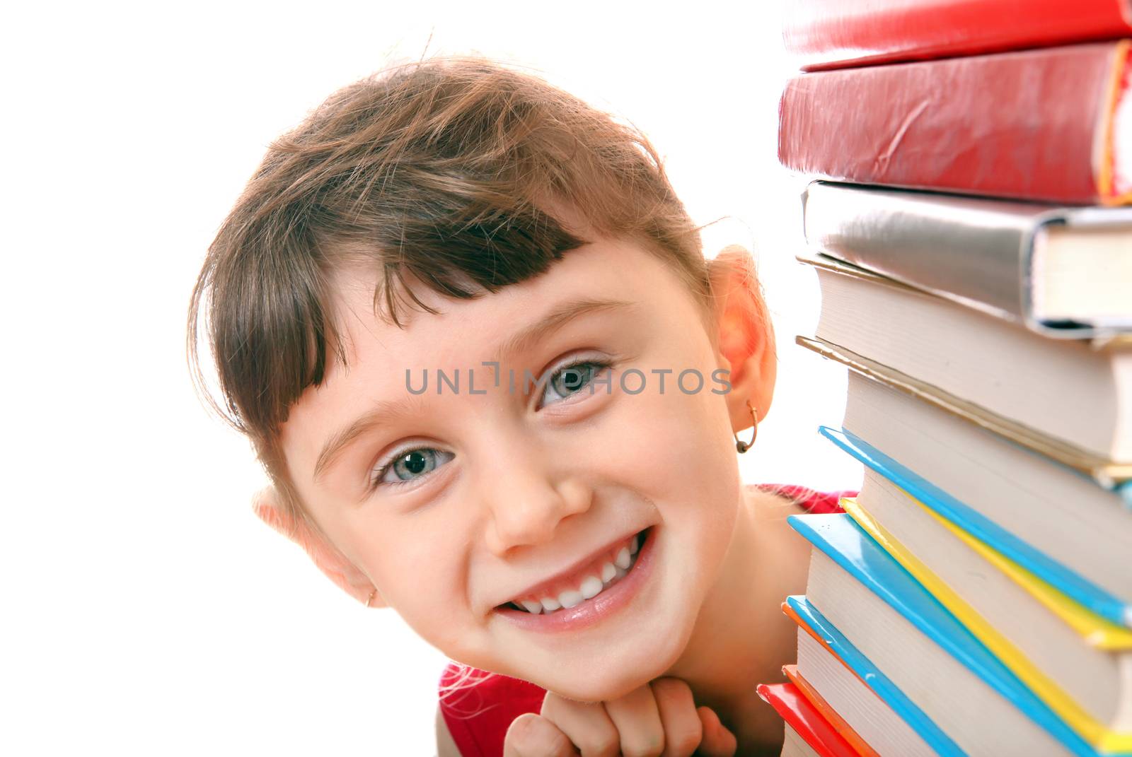 Cheerful Little Girl behind the Books on the White Background