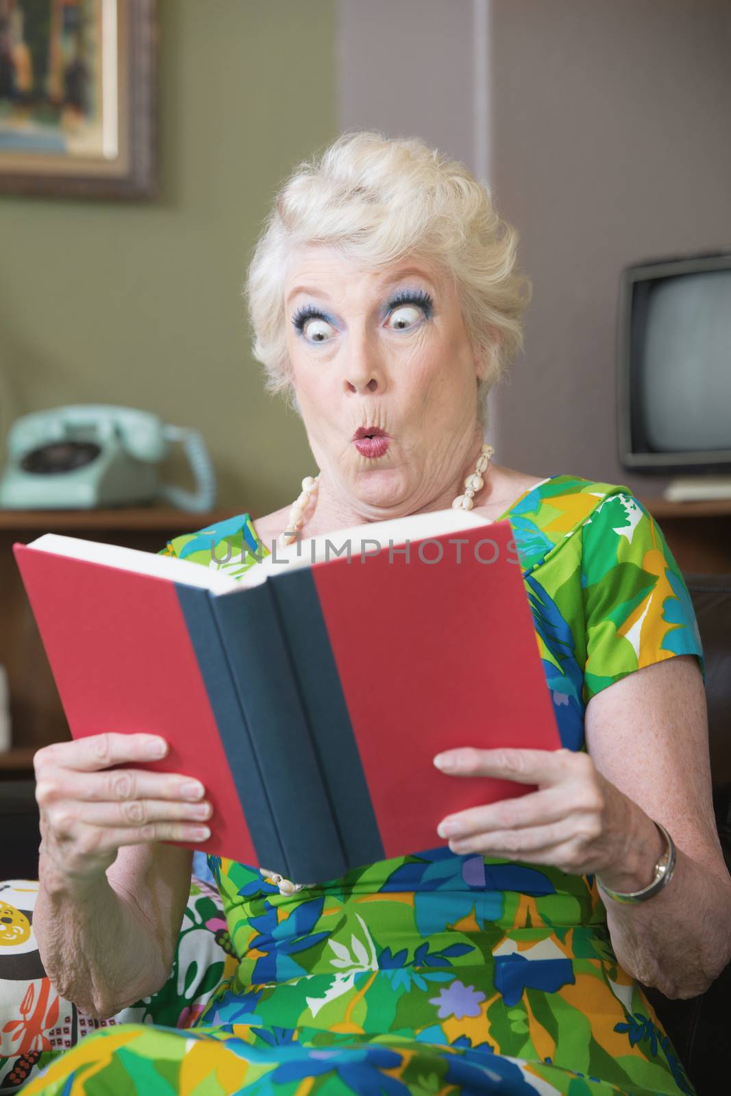 Startled Caucasian woman reading hard cover book