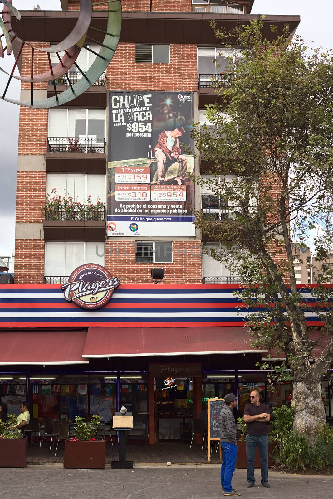 QUITO, ECUADOR - AUGUST 6, 2014: Players Sports Bar and Grill on Plaza Foch in La Mariscal on August 6, 2014 in Quito, Ecuador. The big sign says that there is a fine of 954 USD for drinking in public areas in the tourist districts.