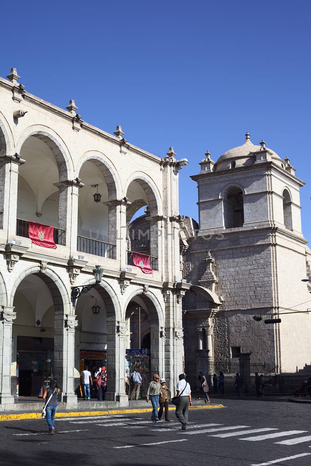 AREQUIPA, PERU - AUGUST 22, 2014: Paseo Portal de Flores and tower of the Iglesia de la Compania at the Plaza de Armas (main square) on August 22, 2014 in Arequipa, Peru. The historic city center of Arequipa is an UNESCO World Cultural Heritage Site. 