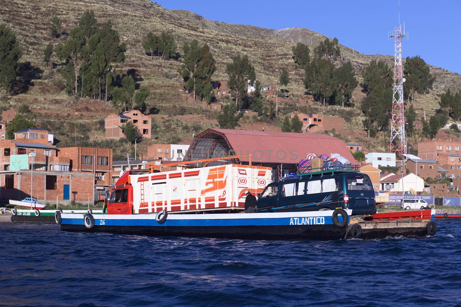 TIQUINA, BOLIVIA - OCTOBER 16, 2014: Wooden ferry loaded with truck and minibus crossing the Strait of Tiquina at Lake Titicaca on October 16, 2014 in San Pablo de Tiquina, Bolivia