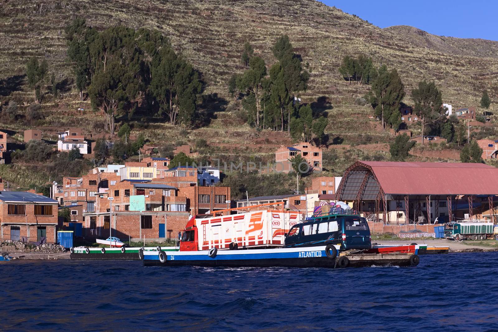 TIQUINA, BOLIVIA - OCTOBER 16, 2014: Wooden ferry loaded with truck and minibus crossing the Strait of Tiquina at Lake Titicaca on October 16, 2014 in San Pablo de Tiquina, Bolivia