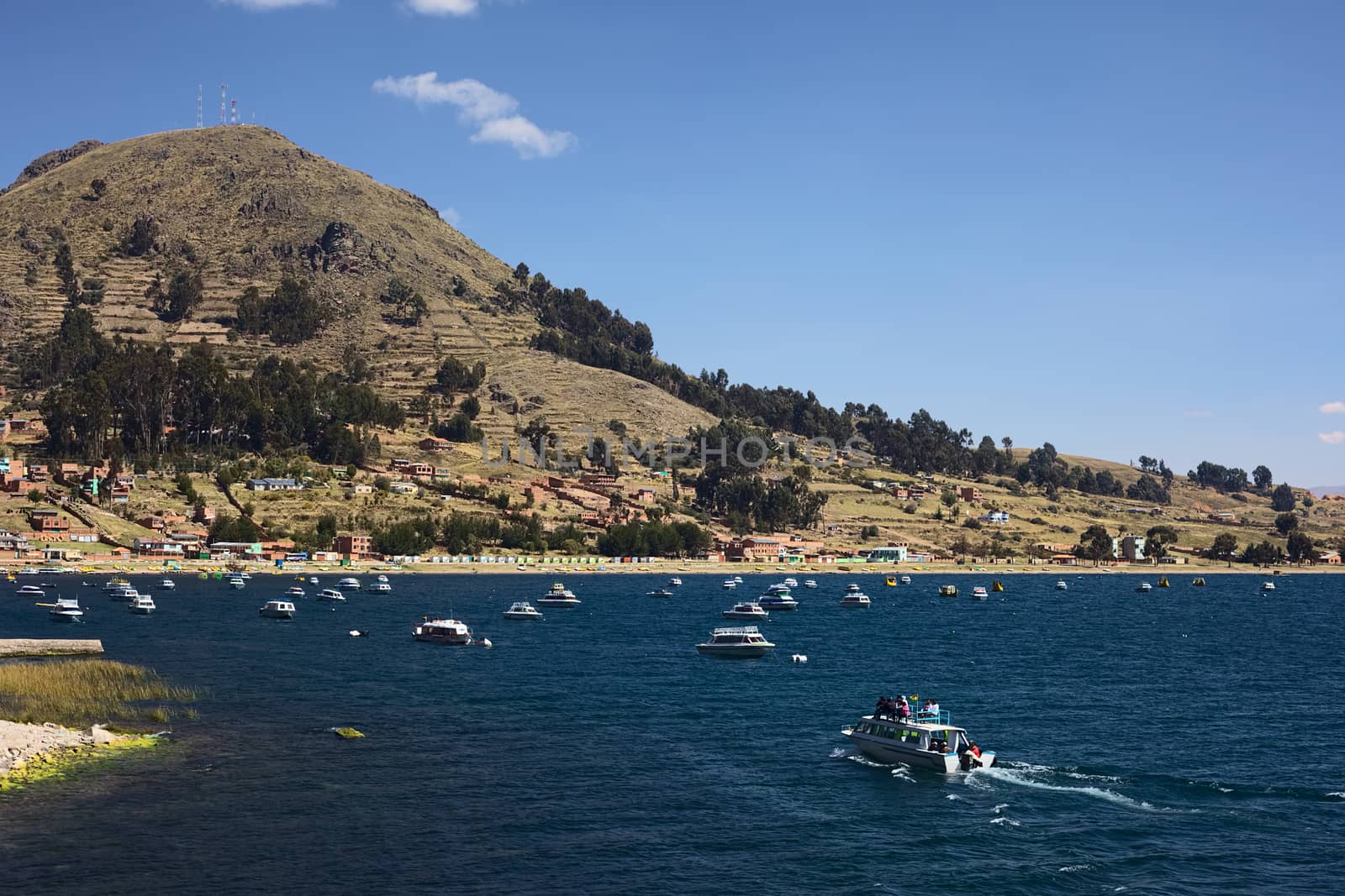 COPACABANA, BOLIVIA - OCTOBER 17, 2014: Tour boat entering the bay of the small tourist town on the shore of Lake Titicaca on October 17, 2014 in Copacabana, Bolivia. Copacabana is the starting and ending point for tours and transportation to Isla del Sol (Sun Island).