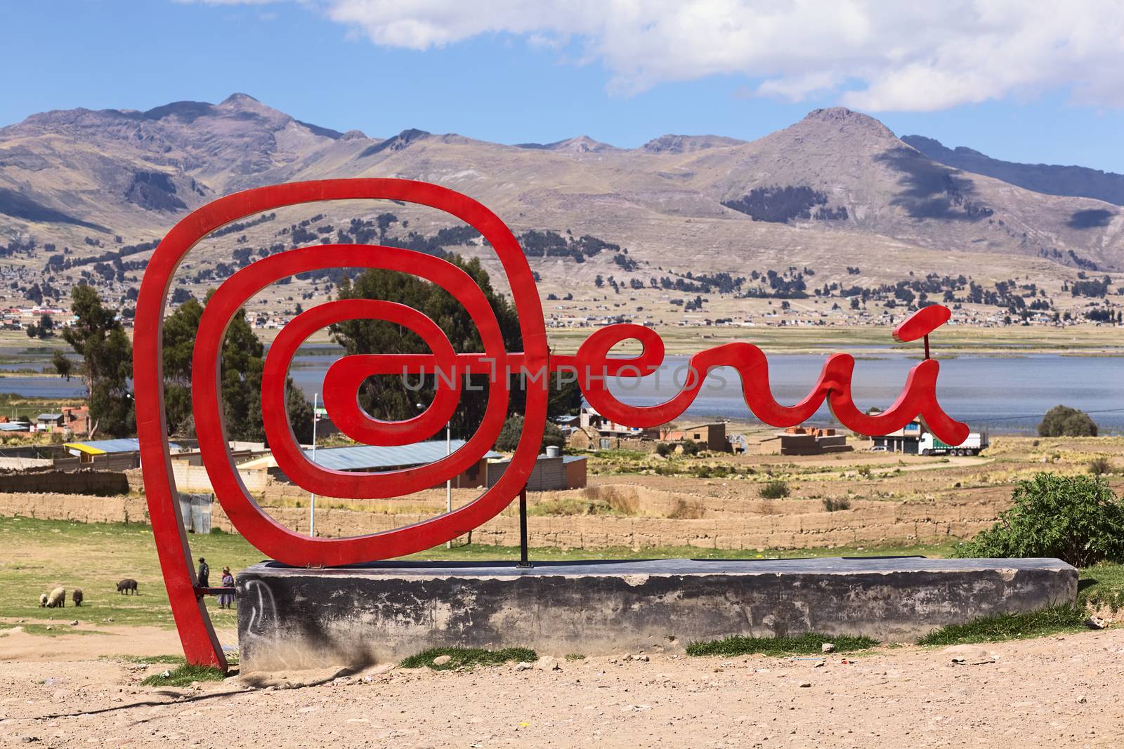 YUNGUYO, PERU - OCTOBER 10, 2014: Red Peru sign along the road close to the border between Bolivia and Peru with view onto Lake Titicaca in the back on October 10, 2014 in Yunguyo, Peru