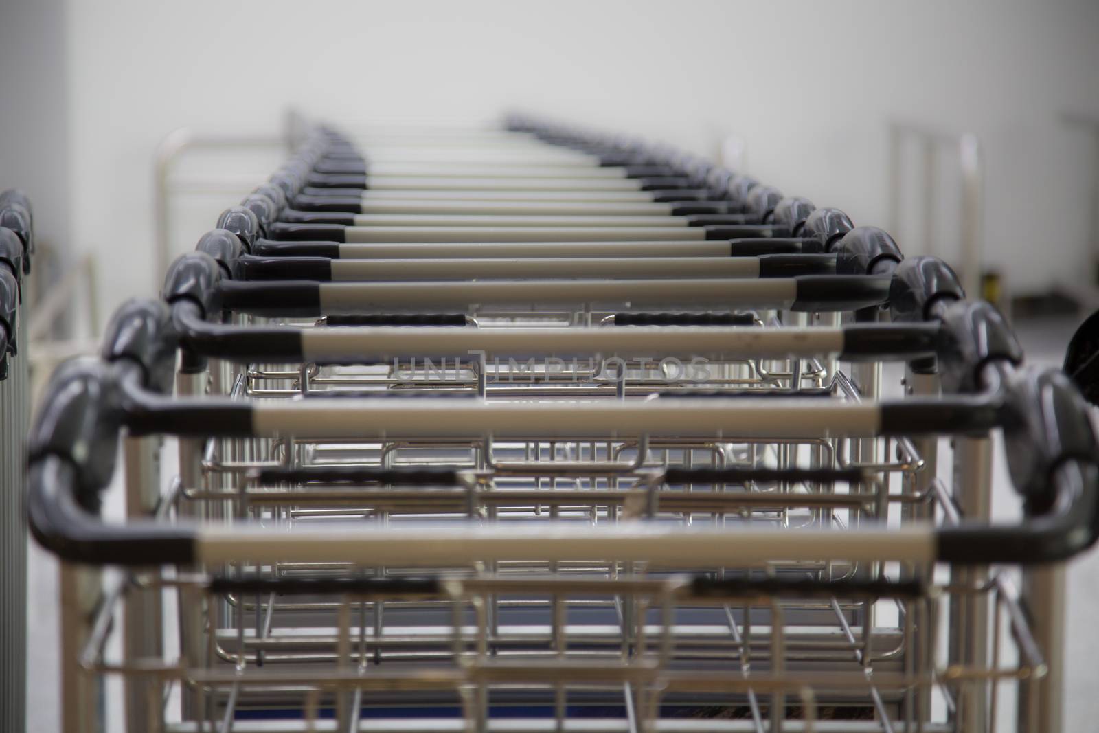 A row of luggage carts at the departure hall in the airport